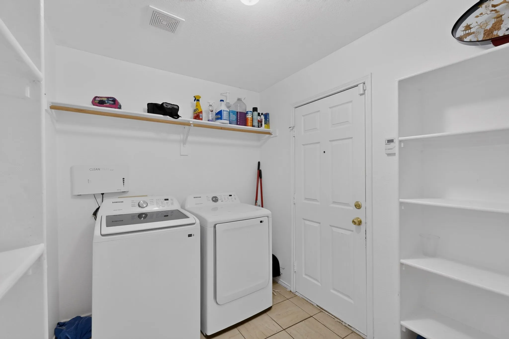 Utility area featuring tiled flooring and a white paneled door