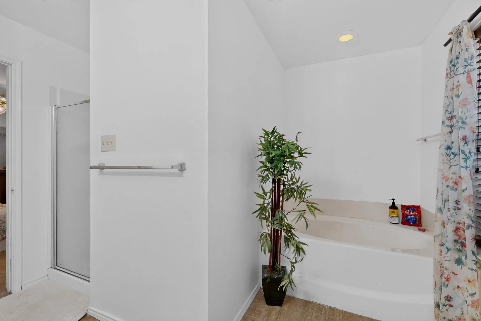 Built-in soaking tub, recessed ceiling lighting, wood-finish flooring, and a glass-enclosed shower