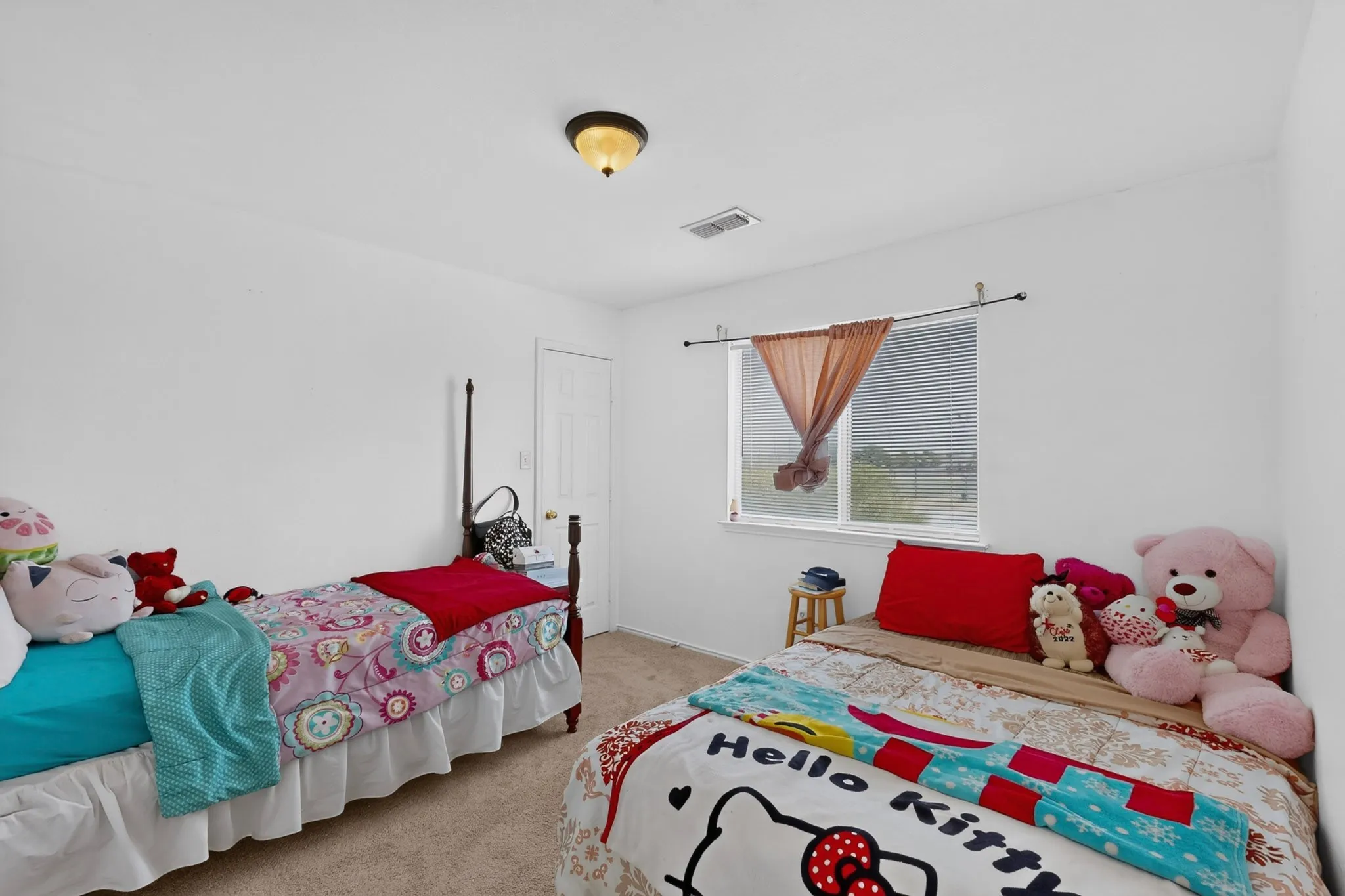 White walls with light neutral carpeting, a single window with blinds, and a built-in ceiling light fixture