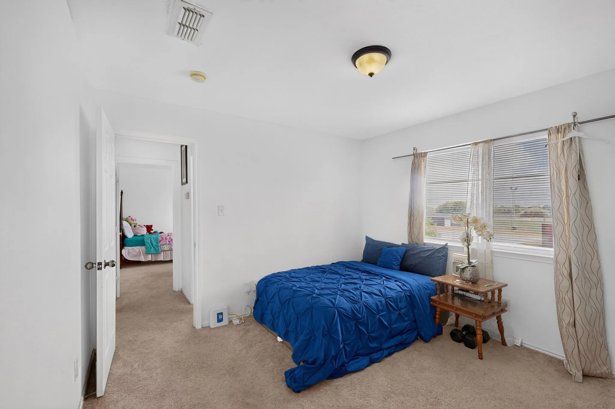 Neutral wall color, carpeted flooring, and a single window with blinds