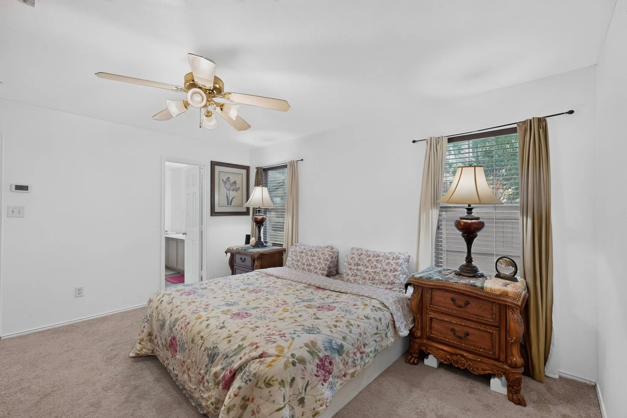 Carpeted flooring throughout, ceiling fan with integrated lighting, and a window with blinds