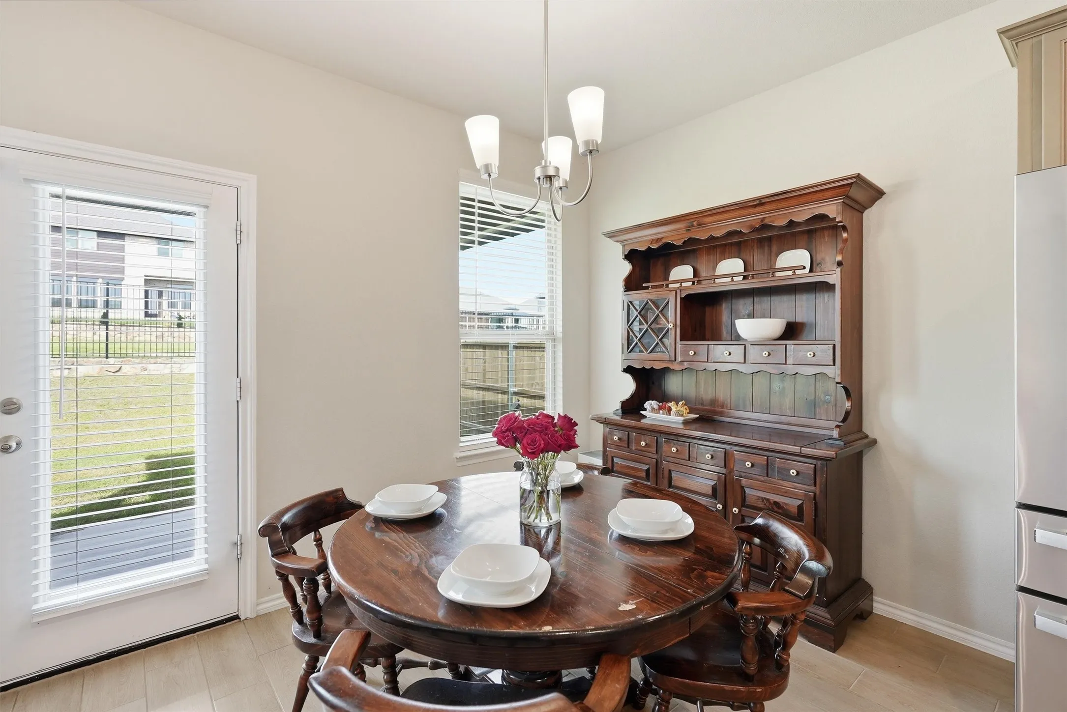 Natural light takes center stage in this inviting dining space, featuring large windows and a glass-paneled door that offers serene views of the backyard.
The open layout ensures a seamless transition from the kitchen, making it ideal for everything from quick breakfasts to formal room.