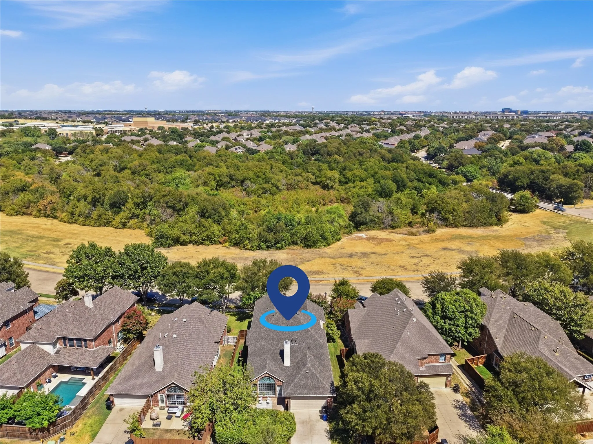 Aerial perspective showcasing residential properties with a natural greenbelt