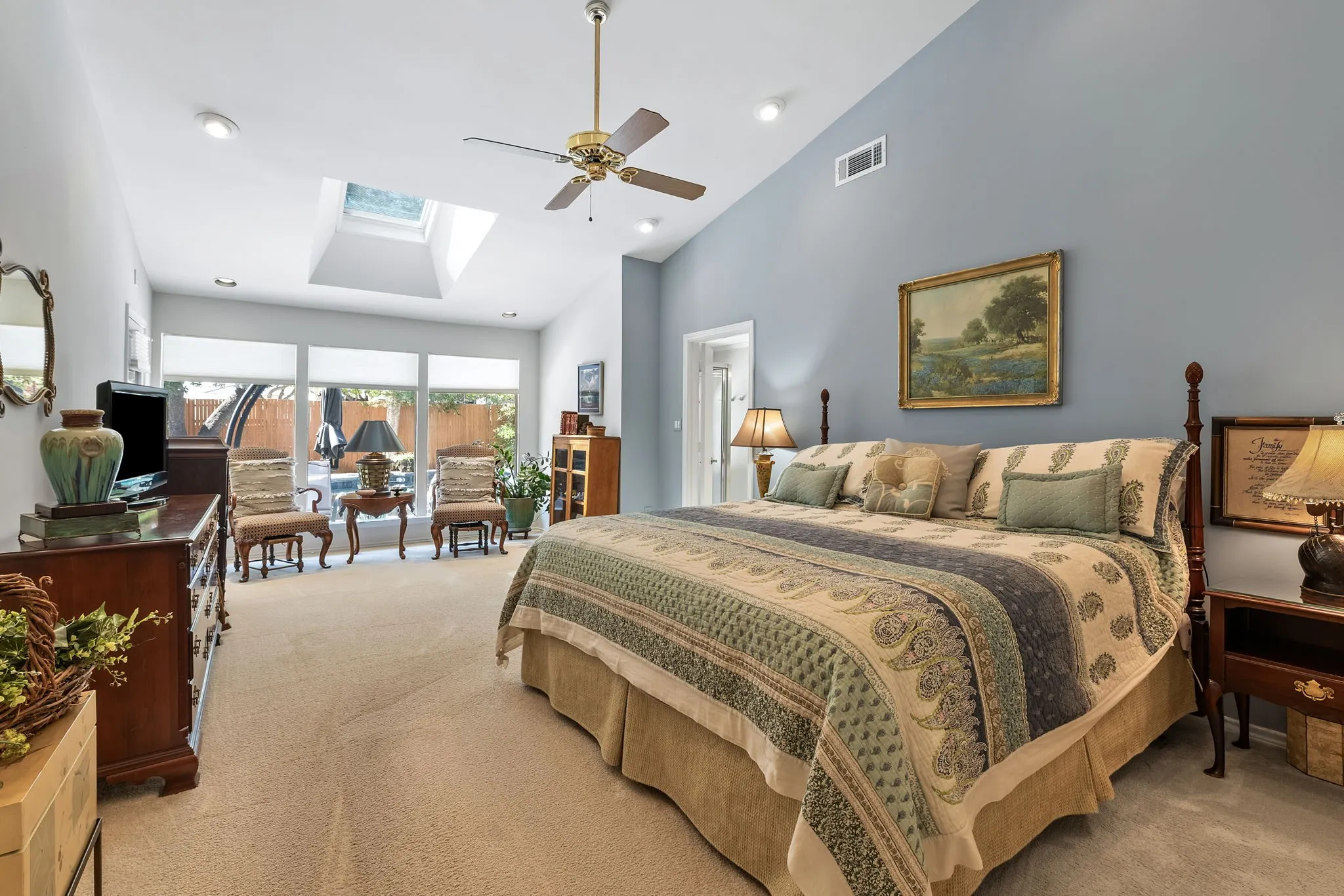 Vaulted ceiling with recessed lighting, skylight, ceiling fan, and expansive windows