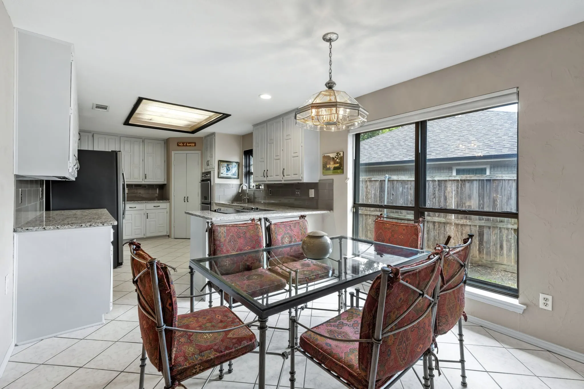 Kitchen with white cabinetry, granite countertops, and tile flooring