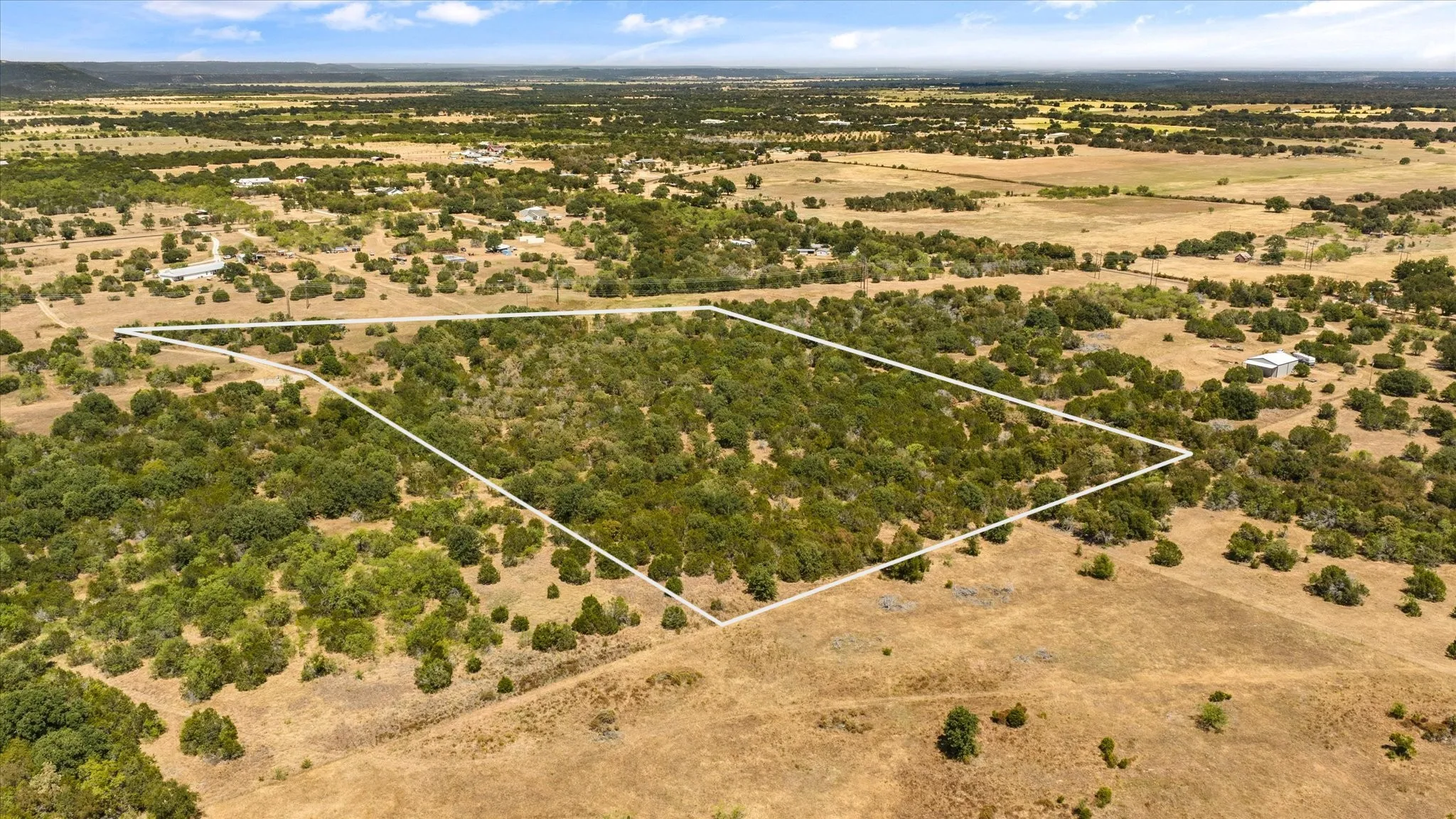 Expansive undeveloped land featuring mature trees and open fields