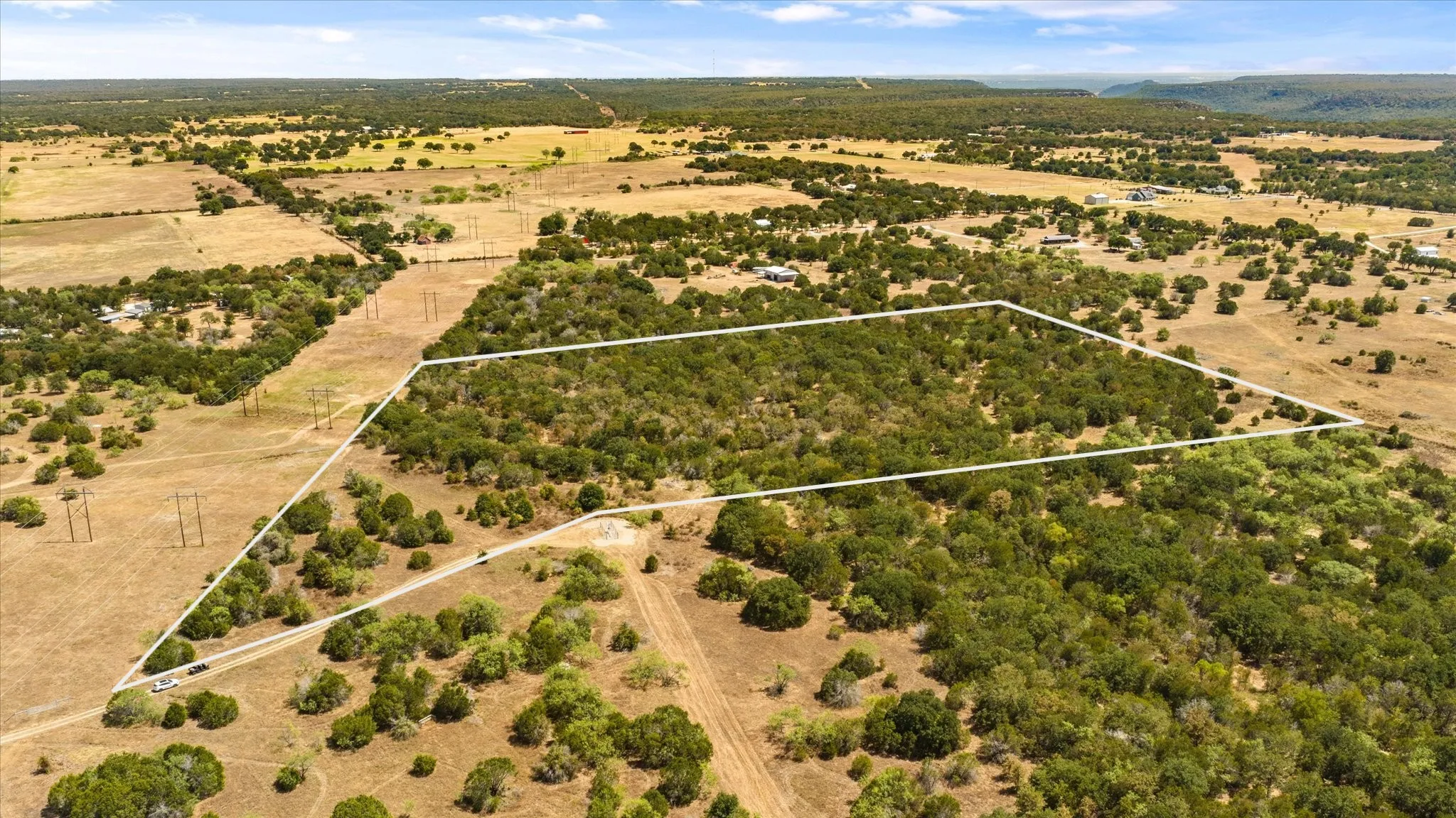 Expansive land parcel featuring dense tree coverage, a natural landscape, and a defined perimeter