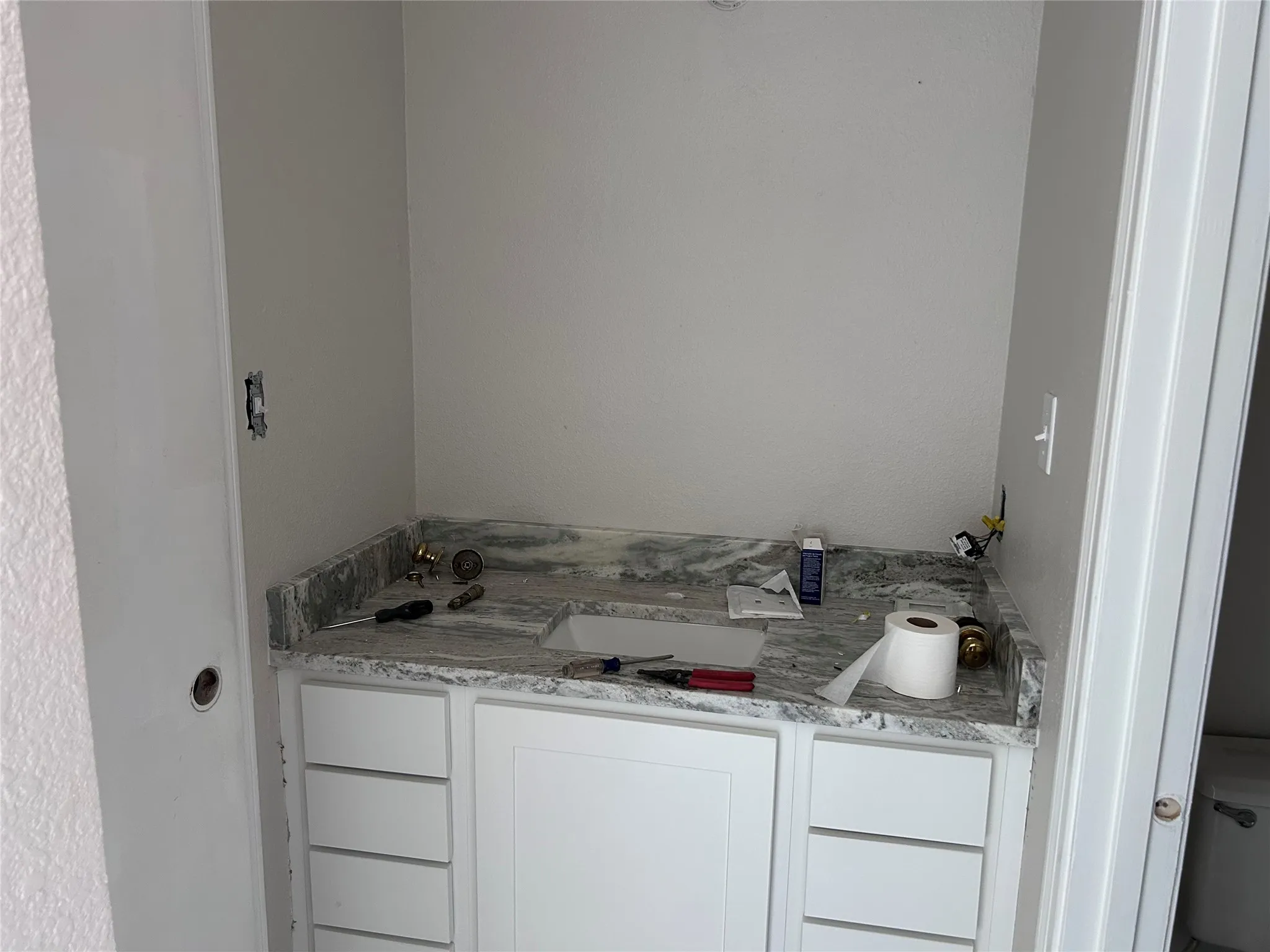 Renovations underway. Private bathroom with new cabinets, granite counters, and sink. Coming soon: new mirror, light fixture, hardware, and vinyl plank flooring.