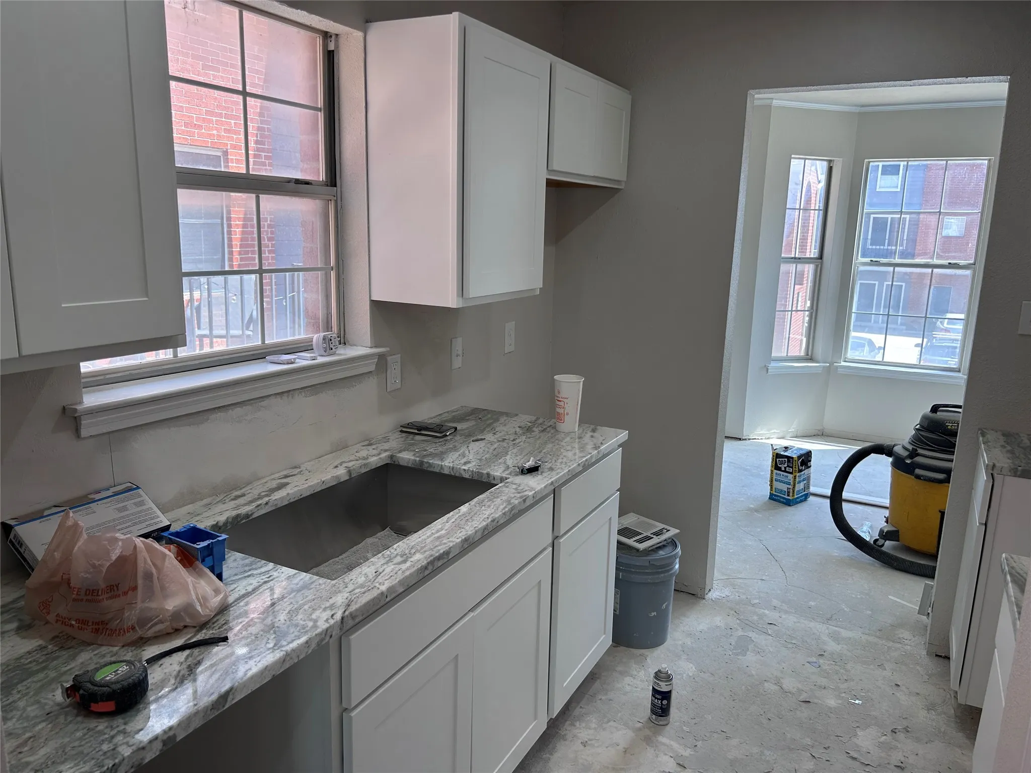 Renovations underway. The kitchen has new Shaker-style cabinets, granite counters, and recessed lighting. New vinyl plank flooring, tile backsplash, sink, 2