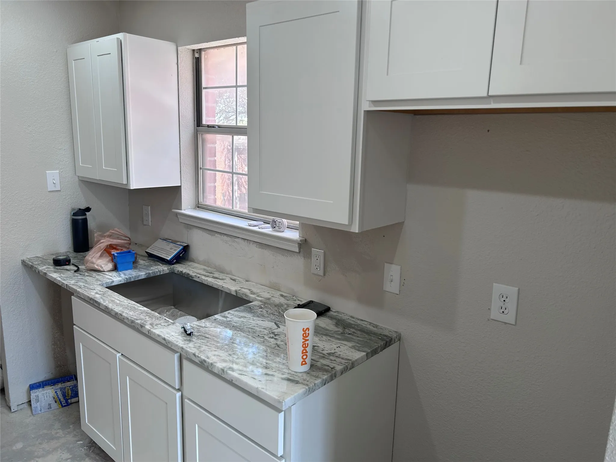 Renovations underway. The kitchen has new Shaker-style cabinets, granite counters, and recessed lighting. New vinyl plank flooring, tile backsplash, sink, 2" blinds, and appliances will be installed soon.