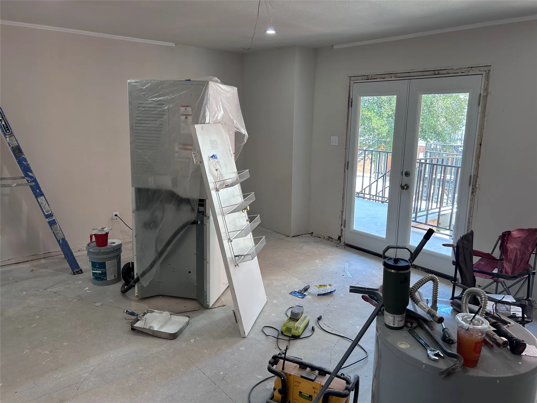 Renovations underway in the family room. New French doors to the balcony and recessed lighting. Vinyl plank flooring and a ceiling fan will be installed soon.