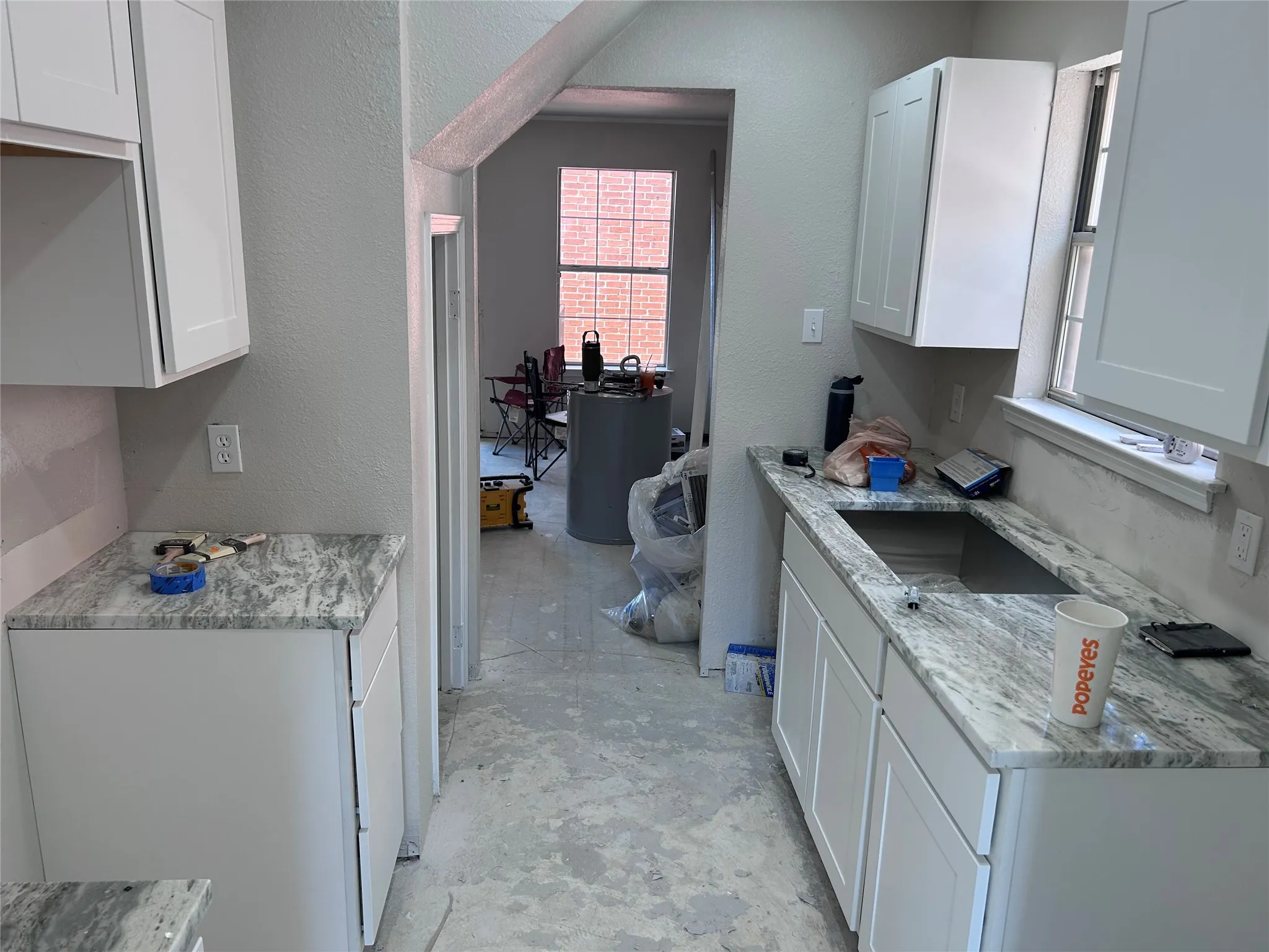 Renovations underway. The kitchen has new Shaker-style cabinets, granite counters, and recessed lighting. New vinyl plank flooring, tile backsplash, sink, 2" blinds, and appliances will be installed soon.