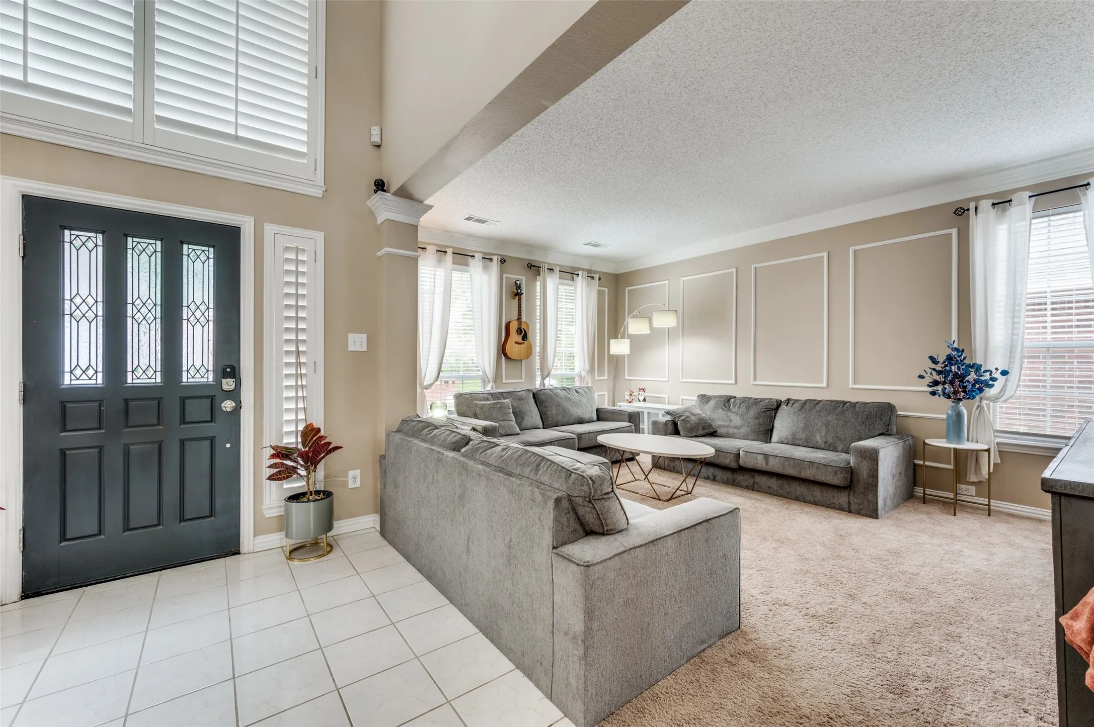 Entryway with white tile flooring and decorative paneling