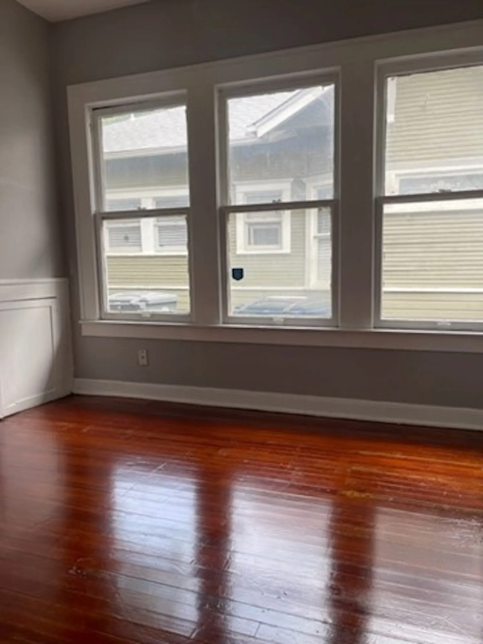 Empty room featuring dark wood-style floors and baseboards