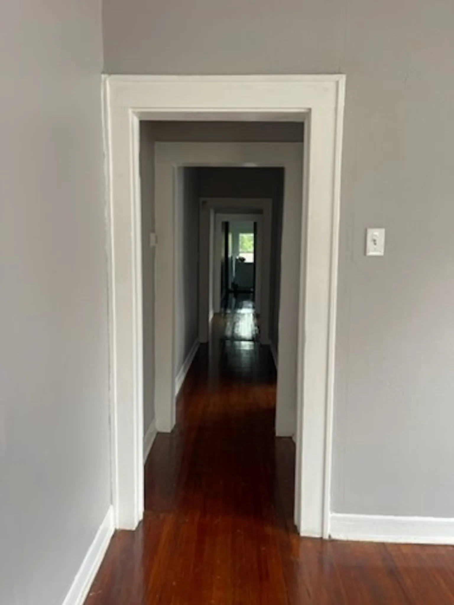 Hallway featuring dark wood-type flooring and baseboards