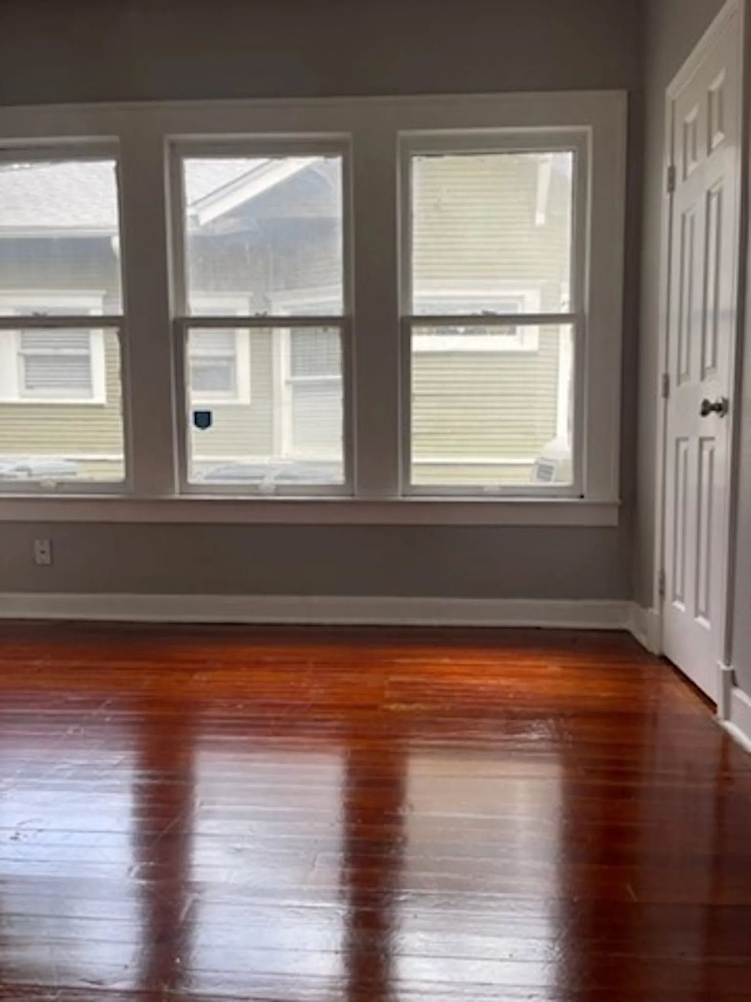 Empty room with dark wood finished floors and baseboards