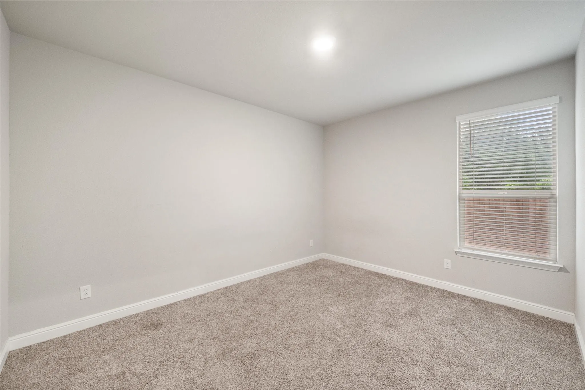 Bedroom 3 with neutral wall tones complement plush carpeting and white baseboards