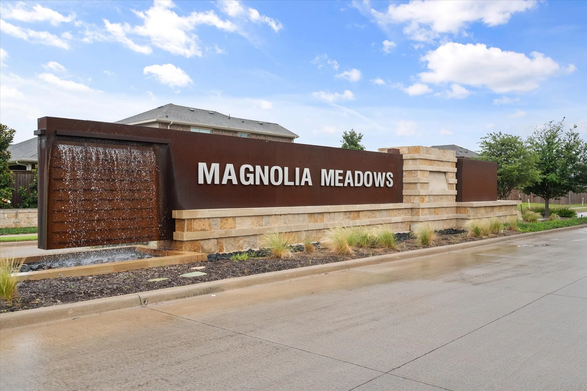 Community entry monument featuring a water feature, stone base, and integrated landscape planting
