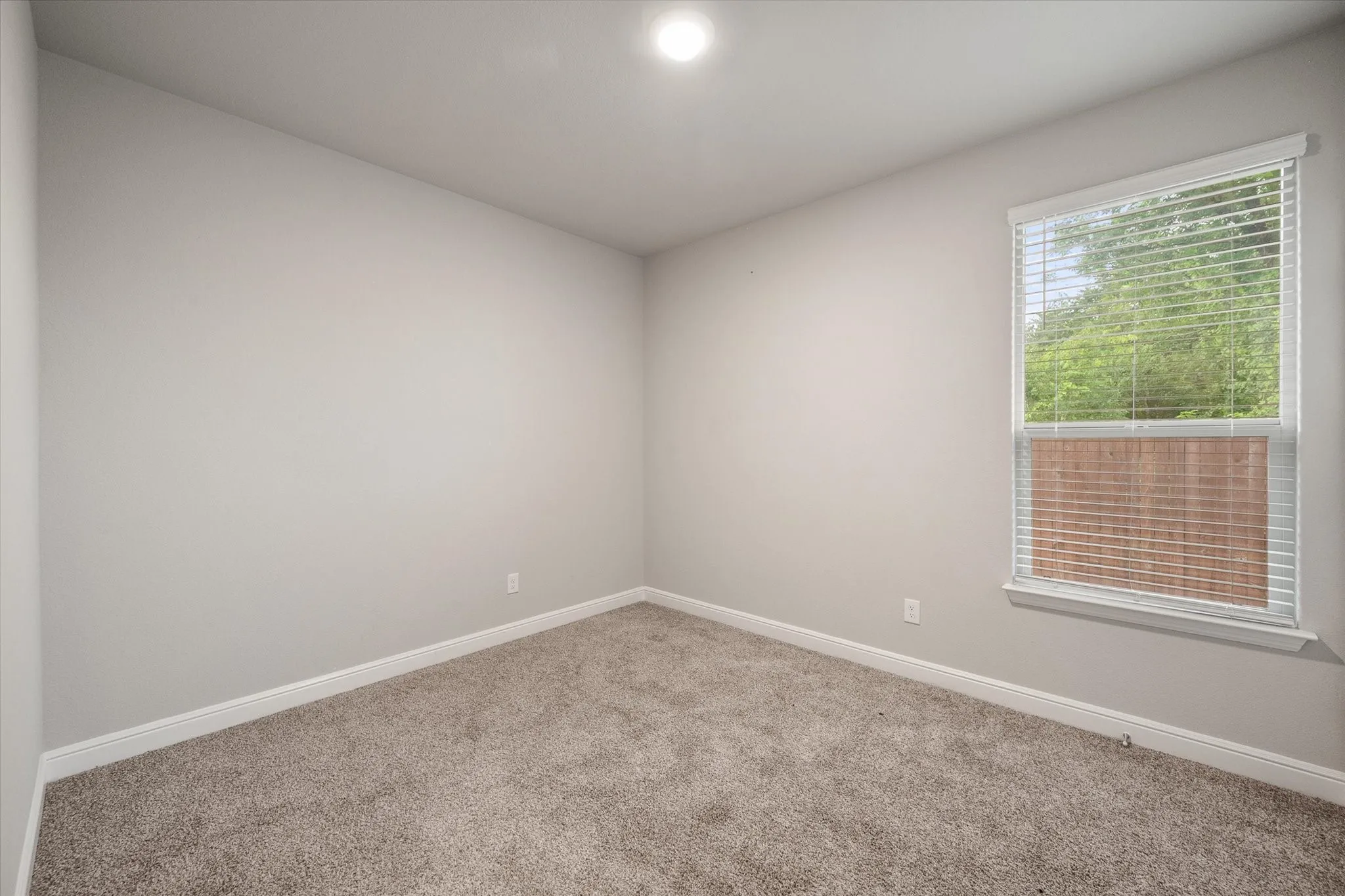 Bedroom 4 also has neutral-toned carpeting paired with light wall paint and white trim