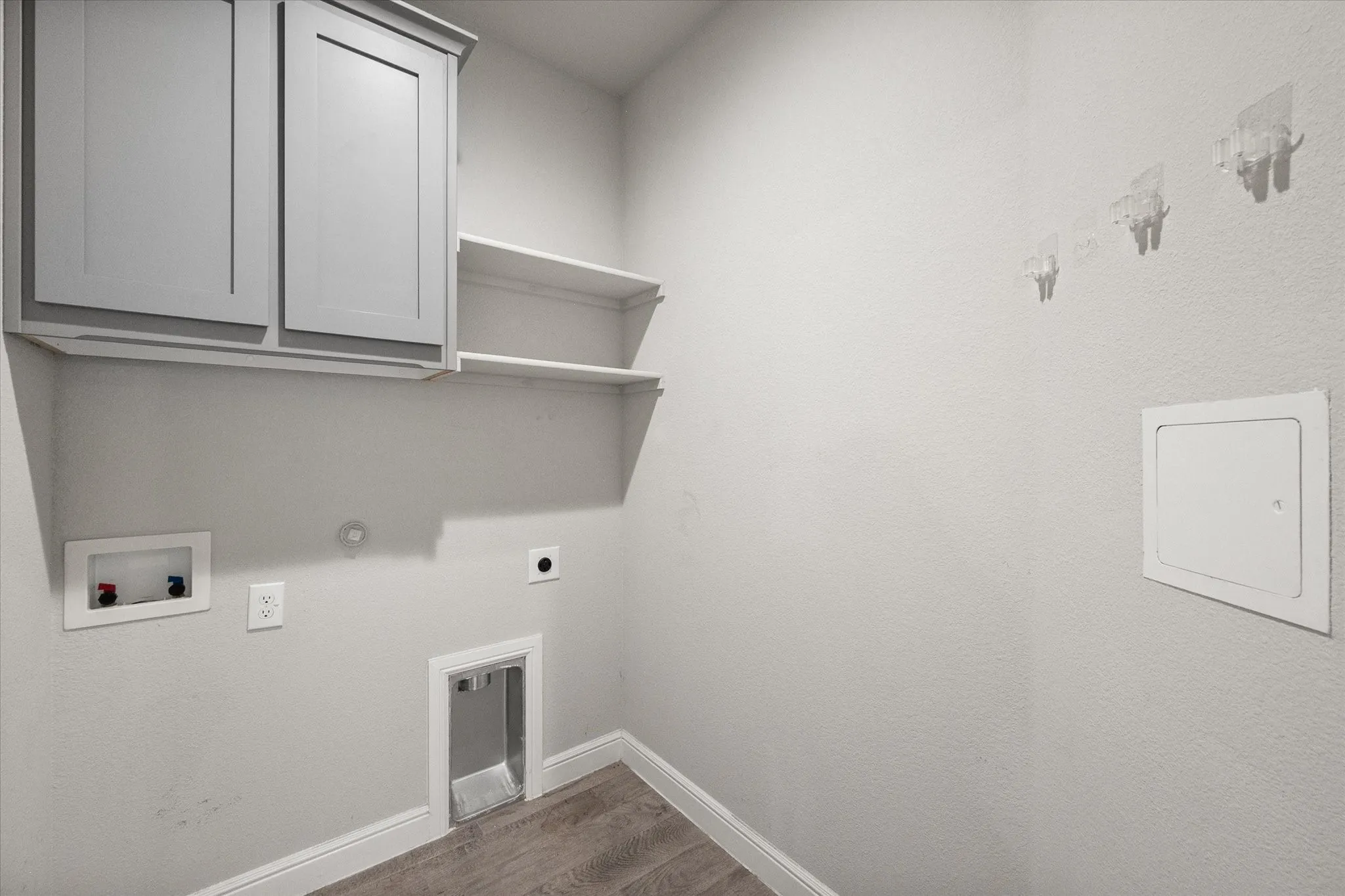 Utility room featuring wood-look tile flooring, light gray cabinetry, a second pantry area and white shelving for storage