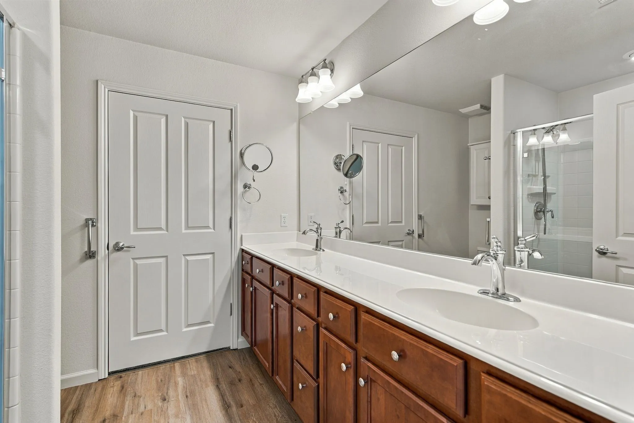 The Owner's Bath Features A Dual Sink Vanity With Abundant Cabinetry And A Sizable Wall Mirror.