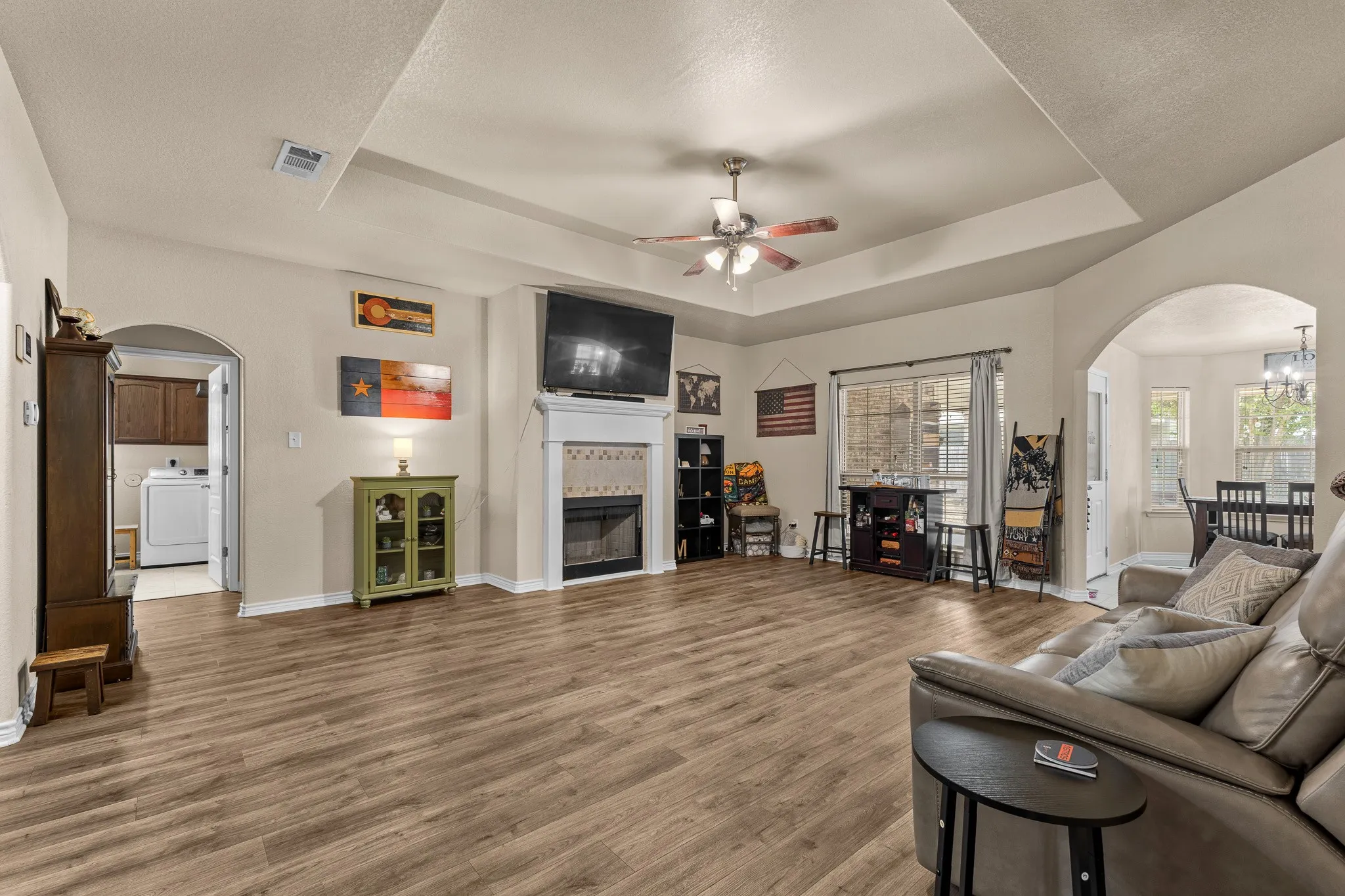 Tray ceiling, wood-finish flooring, recessed lighting, fireplace with mantel, ceiling fan