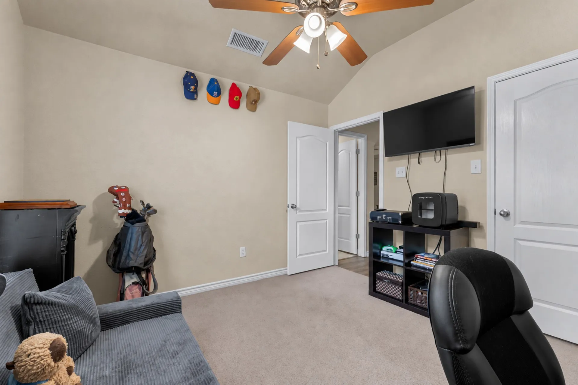 Vaulted ceiling with a ceiling fan, neutral carpet flooring, and white interior doors