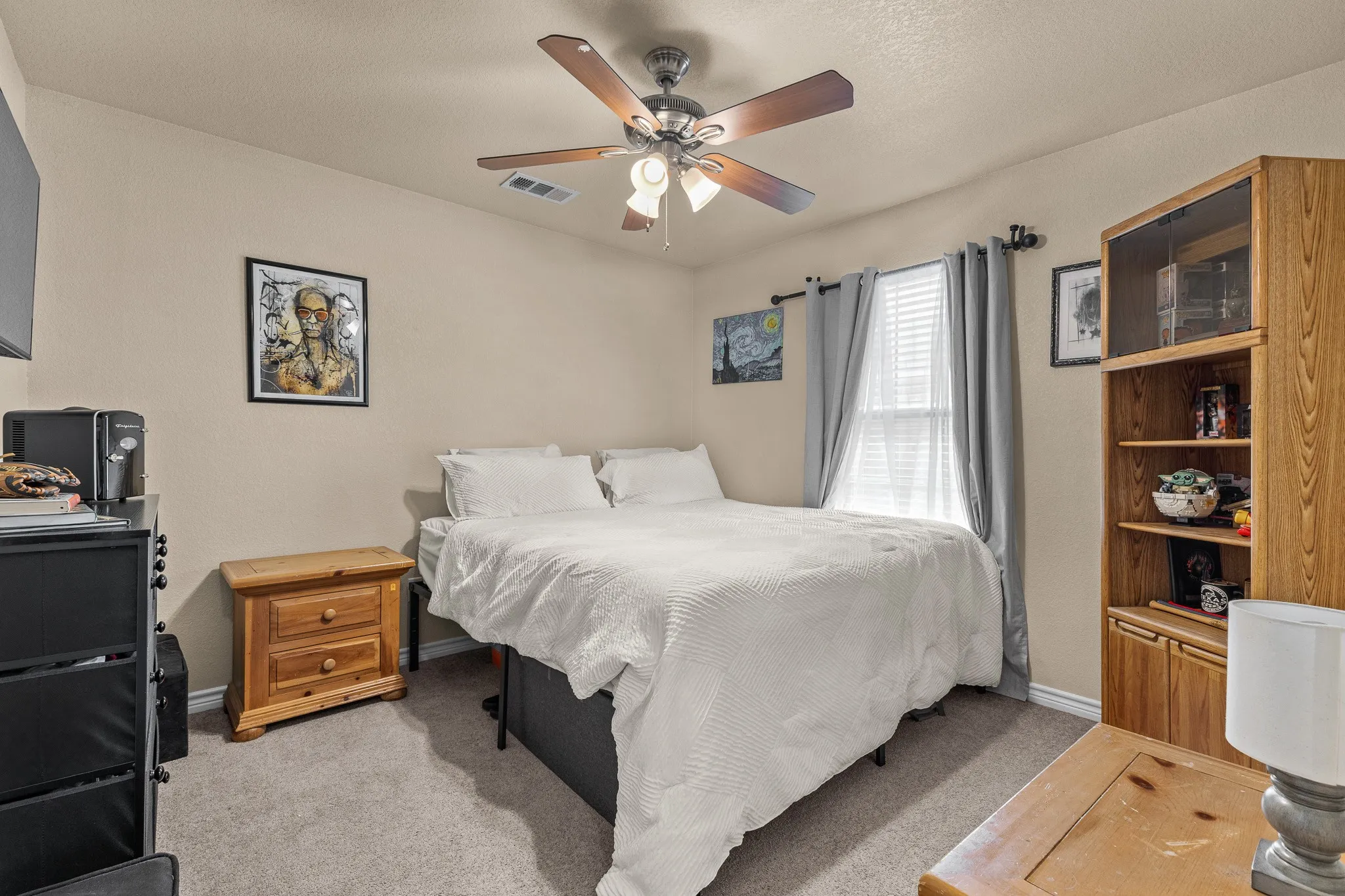 Carpeted flooring, neutral wall paint, ceiling fan with integrated lighting, and window with blinds and drapery