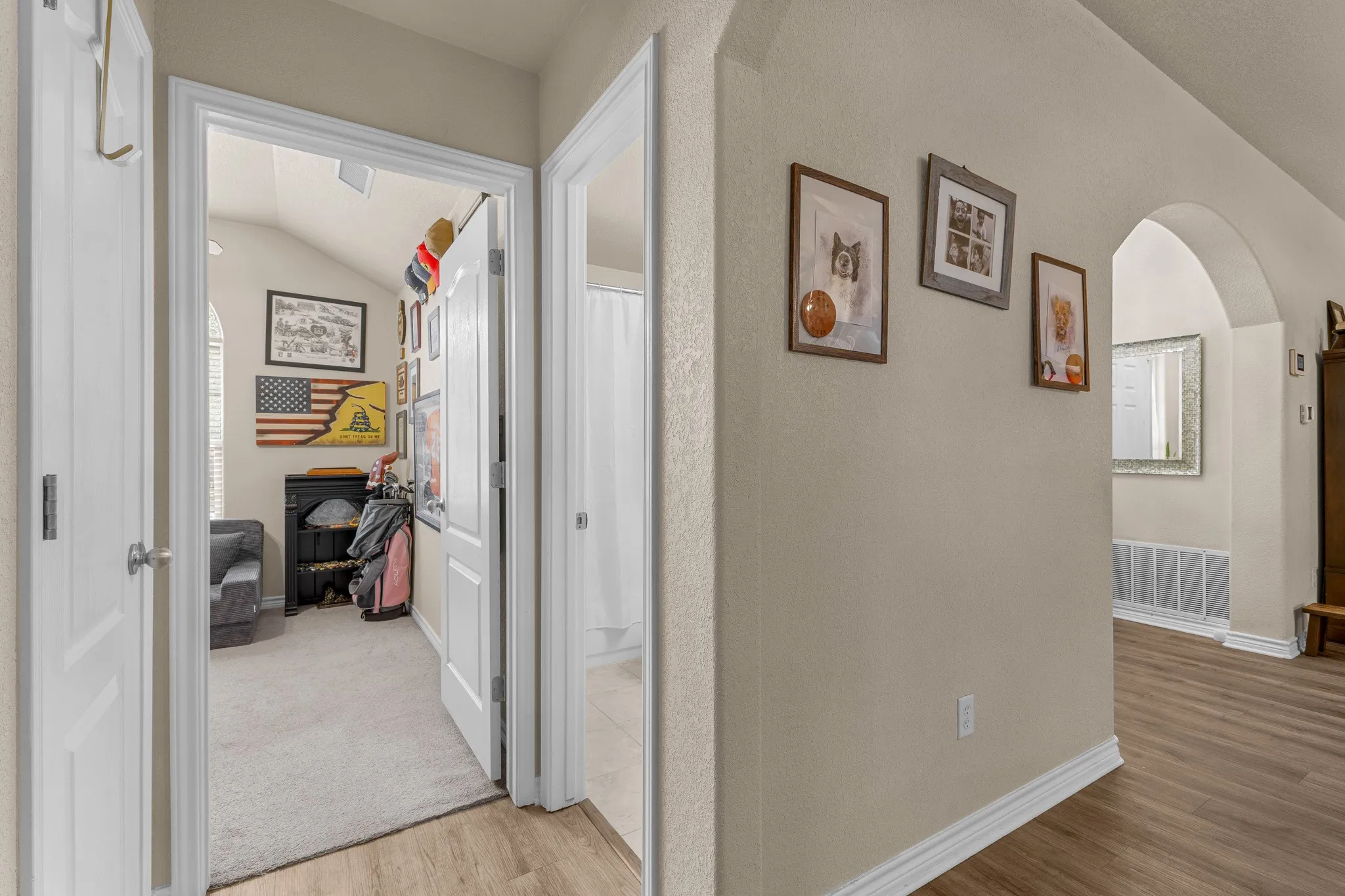 Arched hallway entry with wood-finish flooring