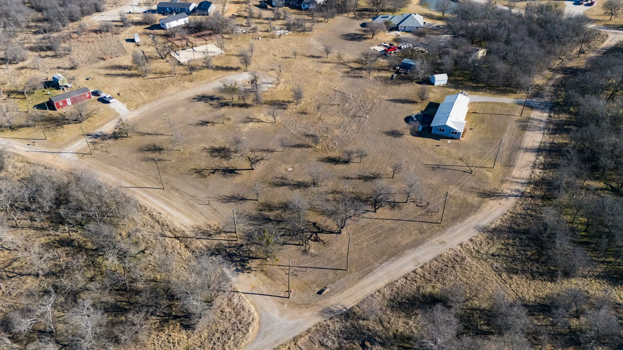 Expansive land parcel with multiple structures and established trees