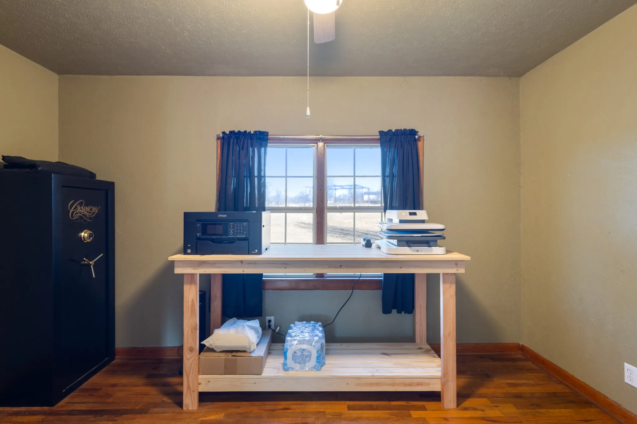 Recessed window with wood trim, wood-finish flooring, and a ceiling fan with light fixture