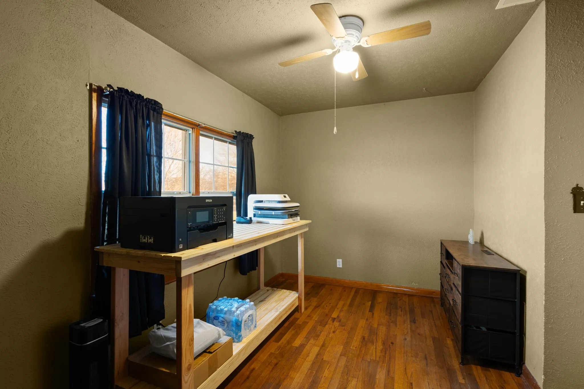Wood-finish flooring, overhead ceiling fan with light, and window with natural light