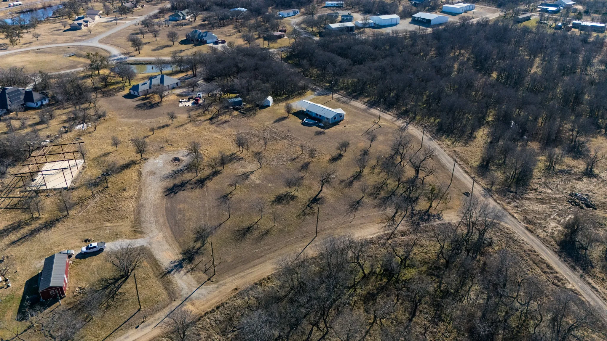 Expansive acreage featuring multiple structures and natural tree coverage