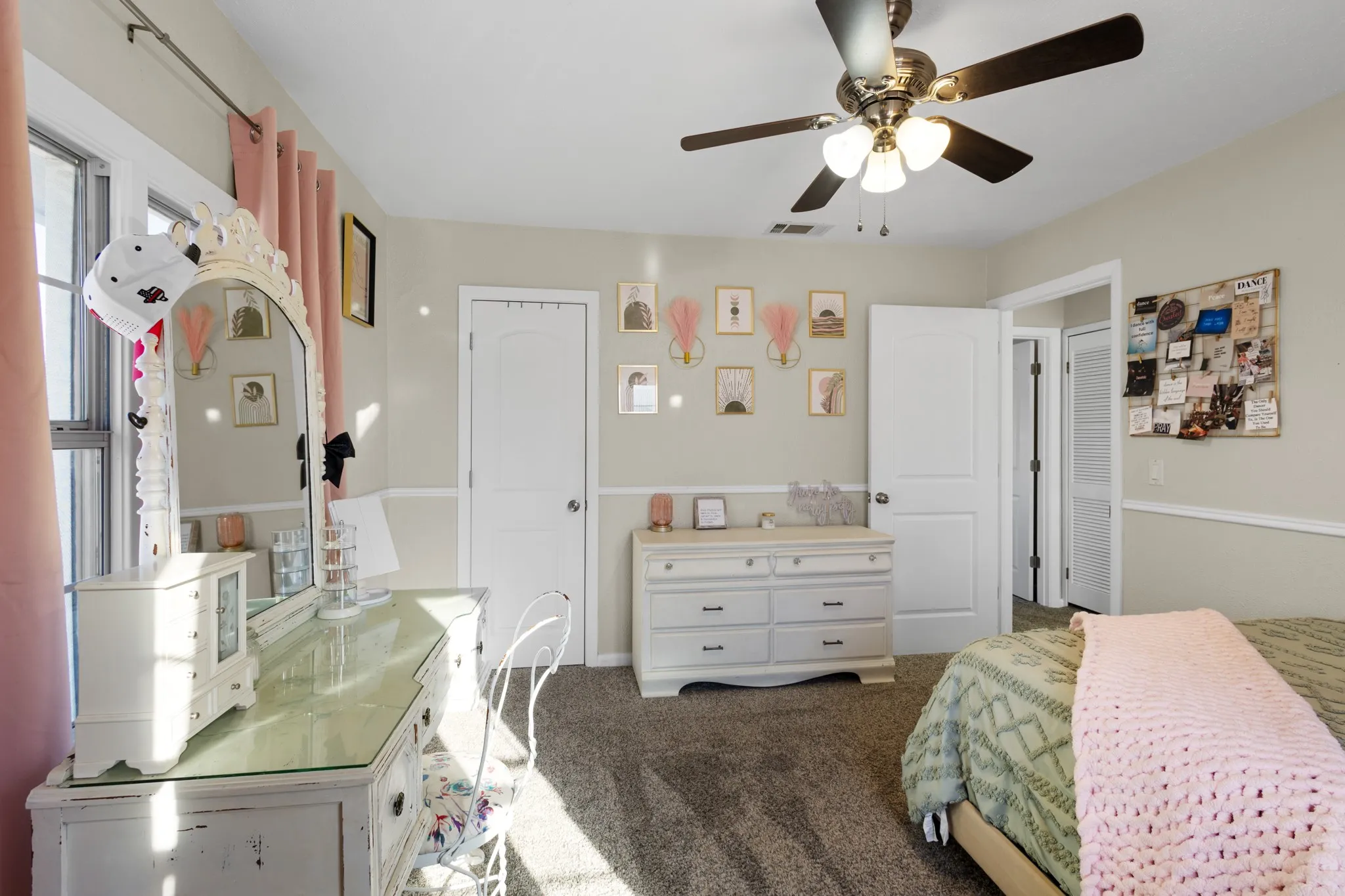 Ceiling fan with light fixture, carpeted flooring, wall trim, white interior doors, and a window