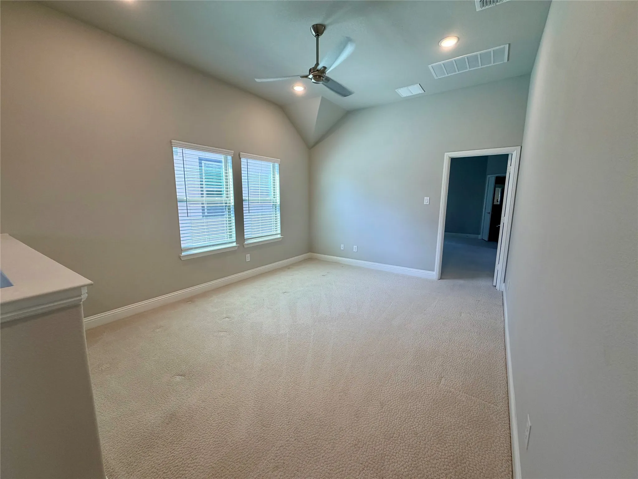 Vaulted ceiling, recessed lighting, ceiling fan, carpet flooring, and dual windows with blinds
