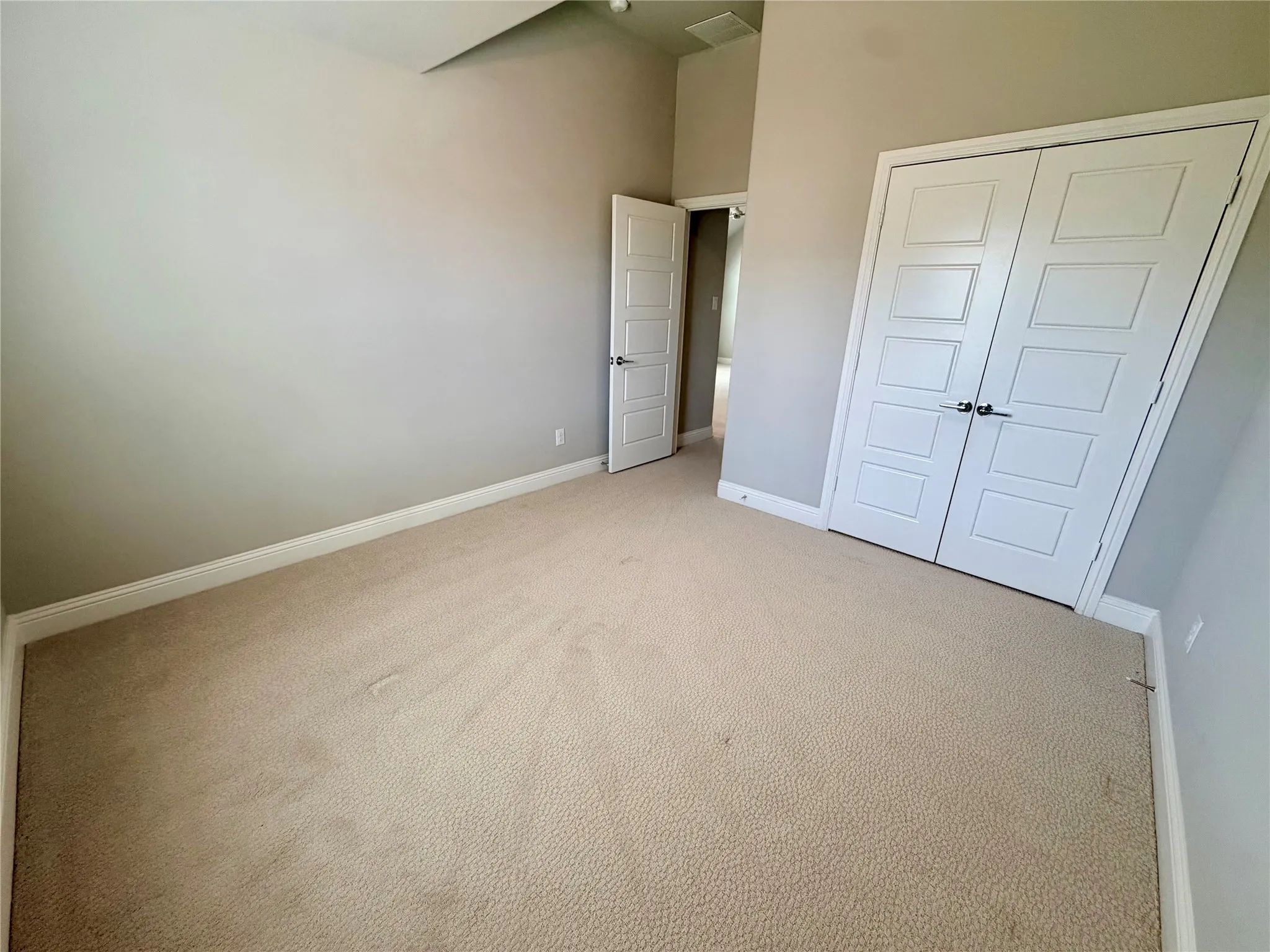 Carpeted flooring, neutral wall tones, white trim, and white paneled doors