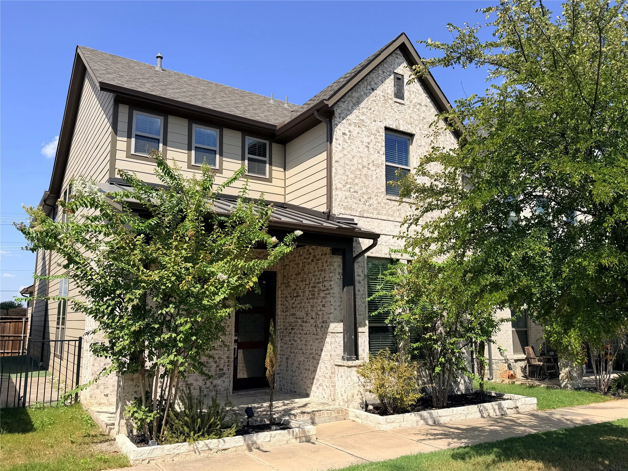 Multi-textured exterior featuring light-colored stone and siding accents