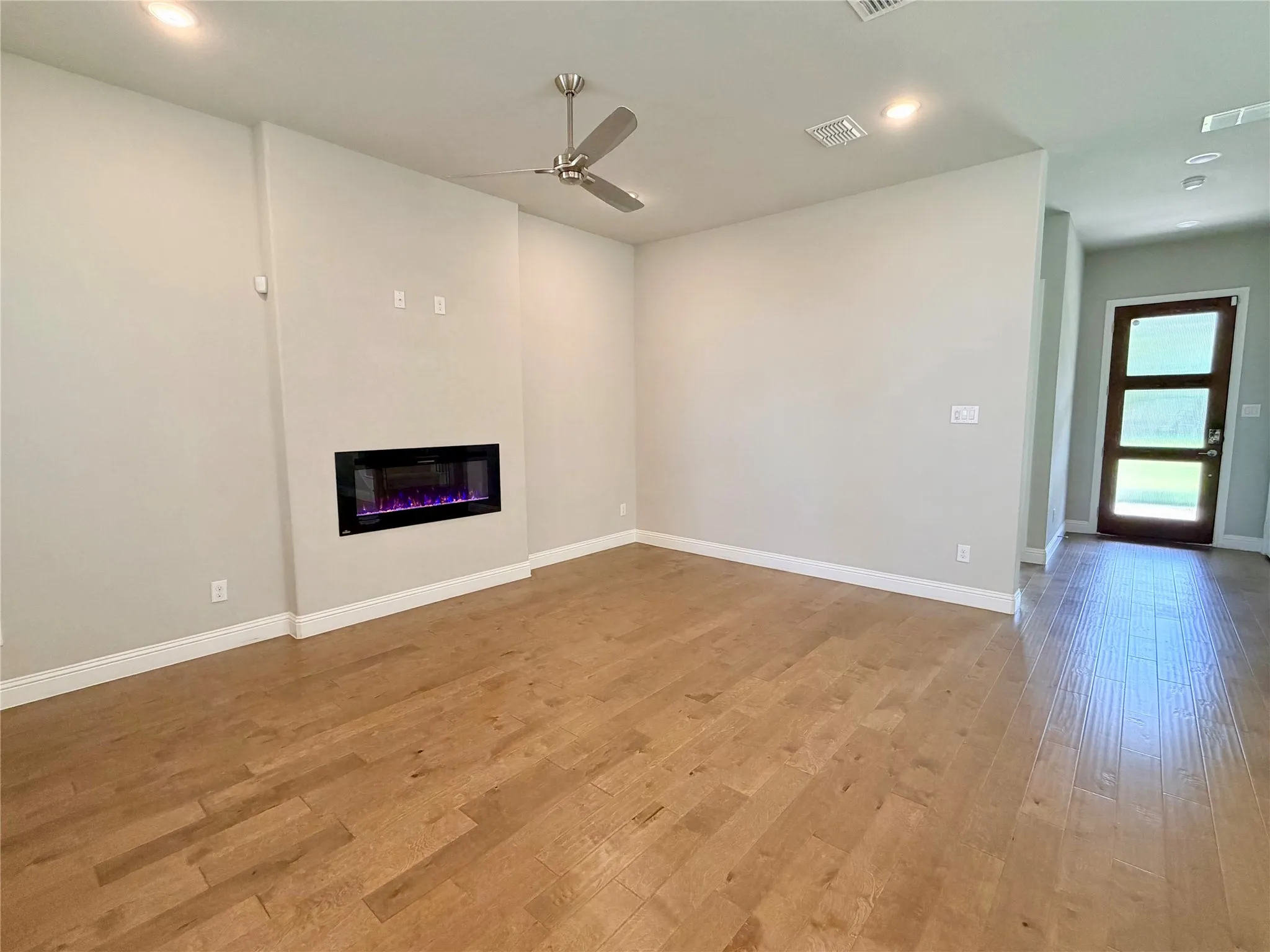 Wood-finish flooring throughout, featuring a linear electric fireplace