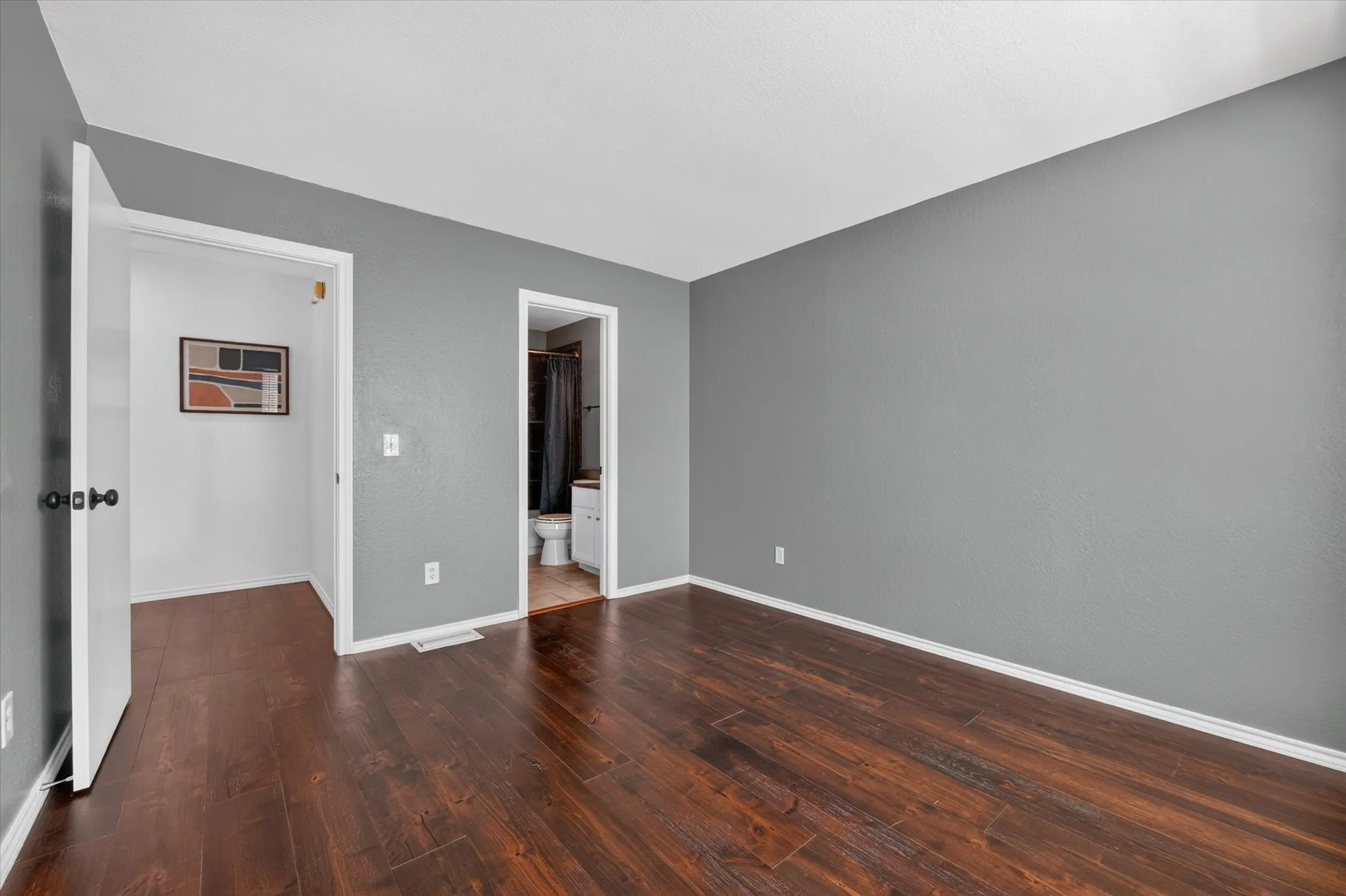 Dark wood-finish flooring with light baseboards