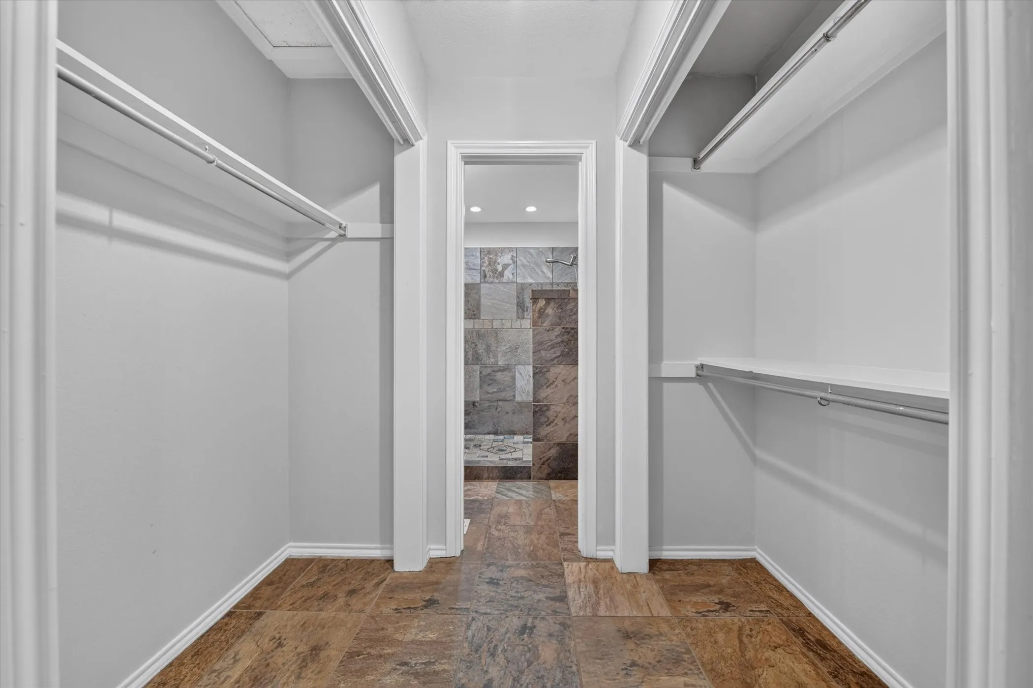 Walk-through closet with built-in shelving and hanging rods
