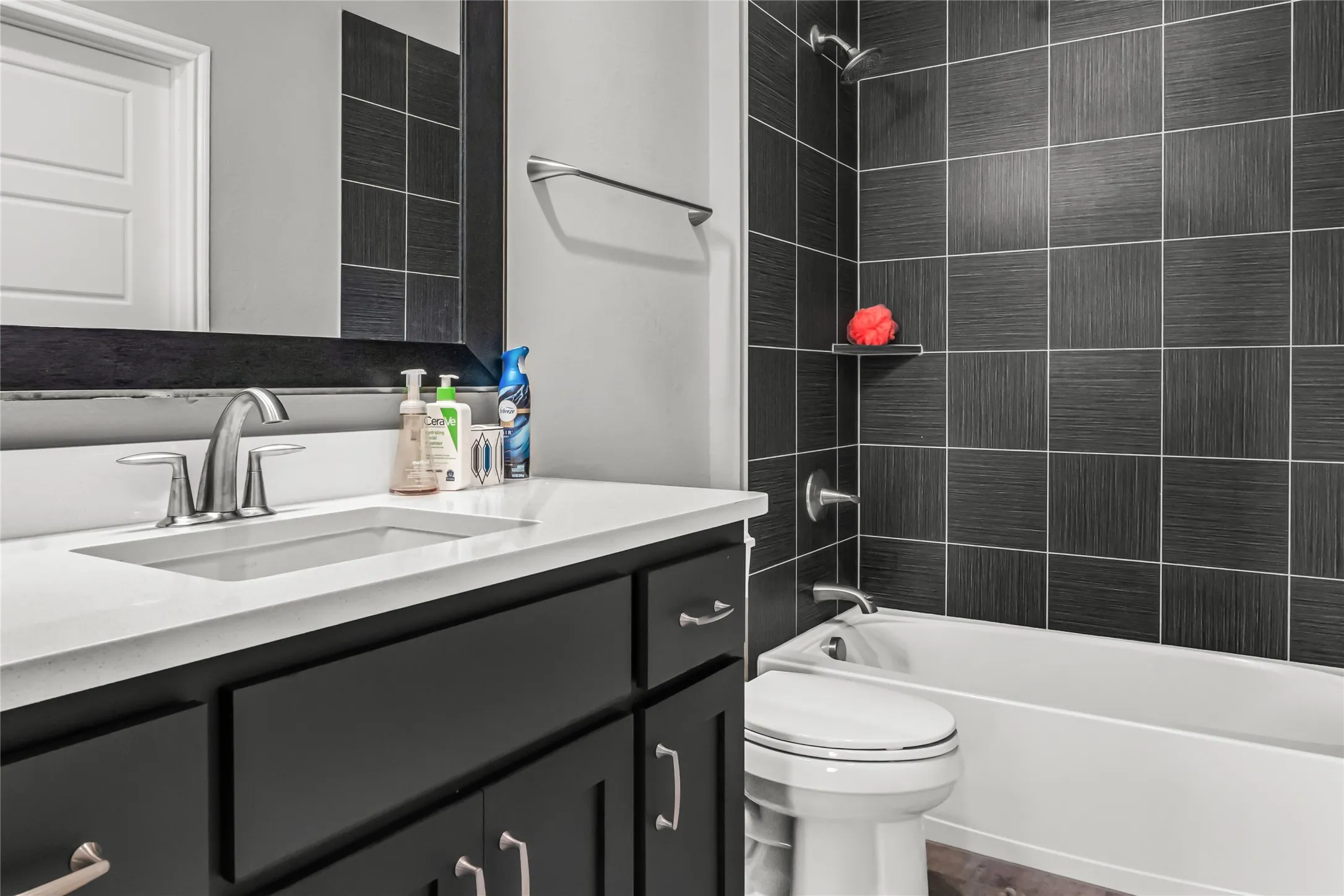 Vanity with a rectangular undermount sink, brushed nickel faucet, and white countertop