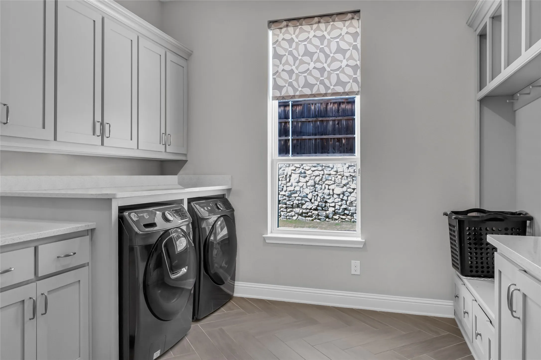 Built-in cabinetry, stone-look countertops, wood-finish flooring, and a built-in bench with storage drawers