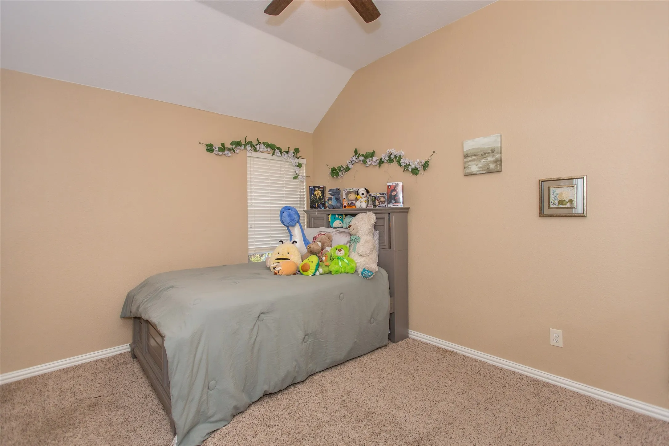 Vaulted ceiling with a ceiling fan, window with blinds, and neutral carpeting