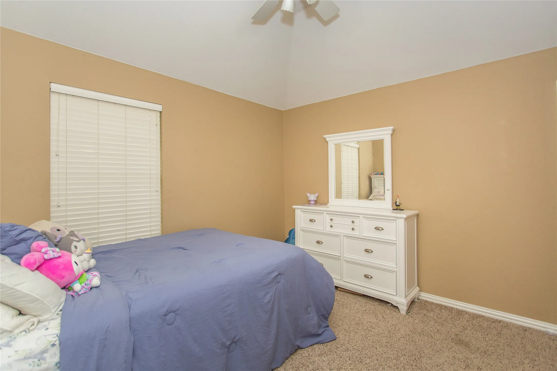 Vaulted ceiling with a ceiling fan, window with blinds, and neutral tone walls