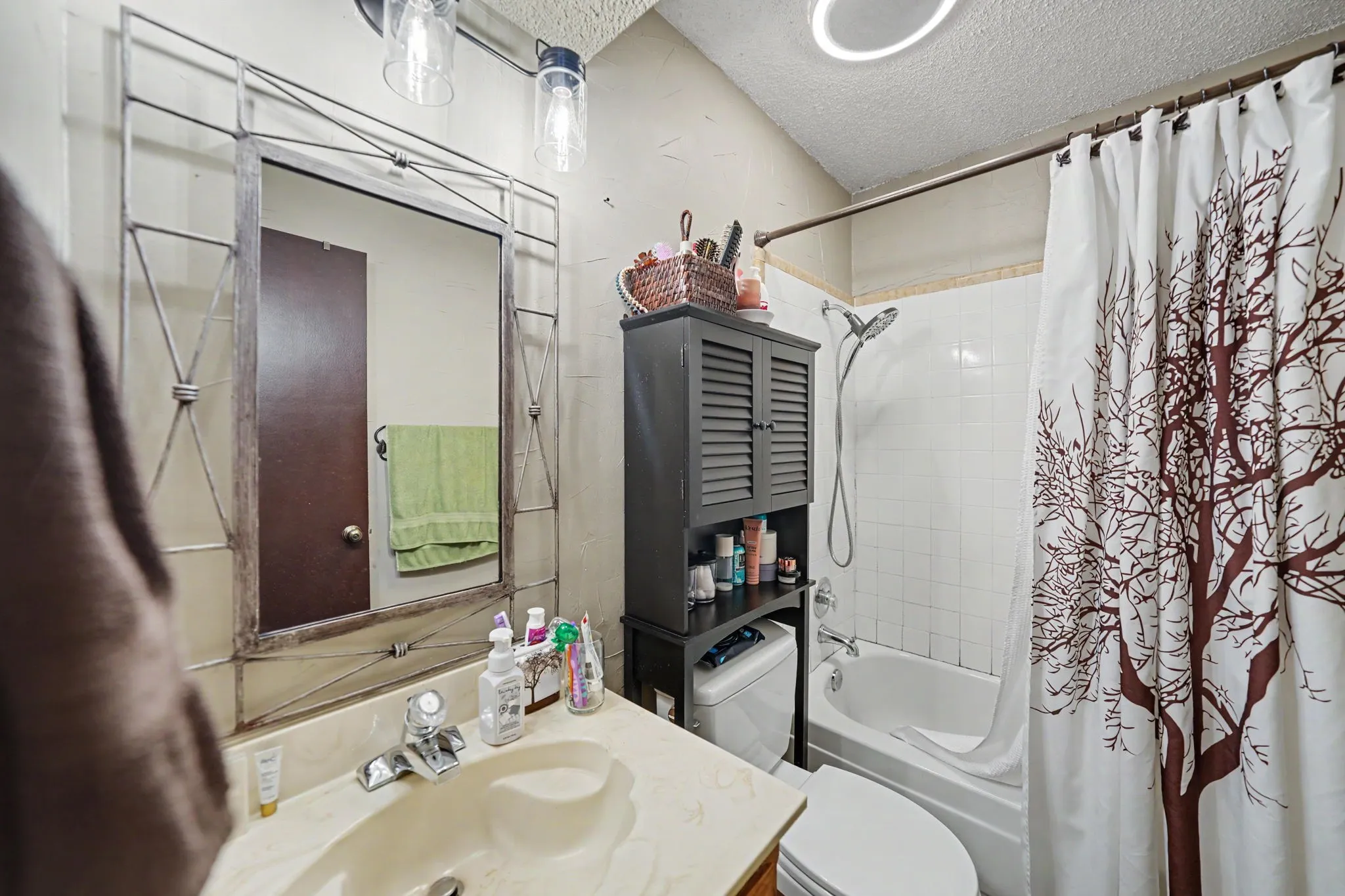Vanity with integrated sink, chrome faucet, and decorative mirror