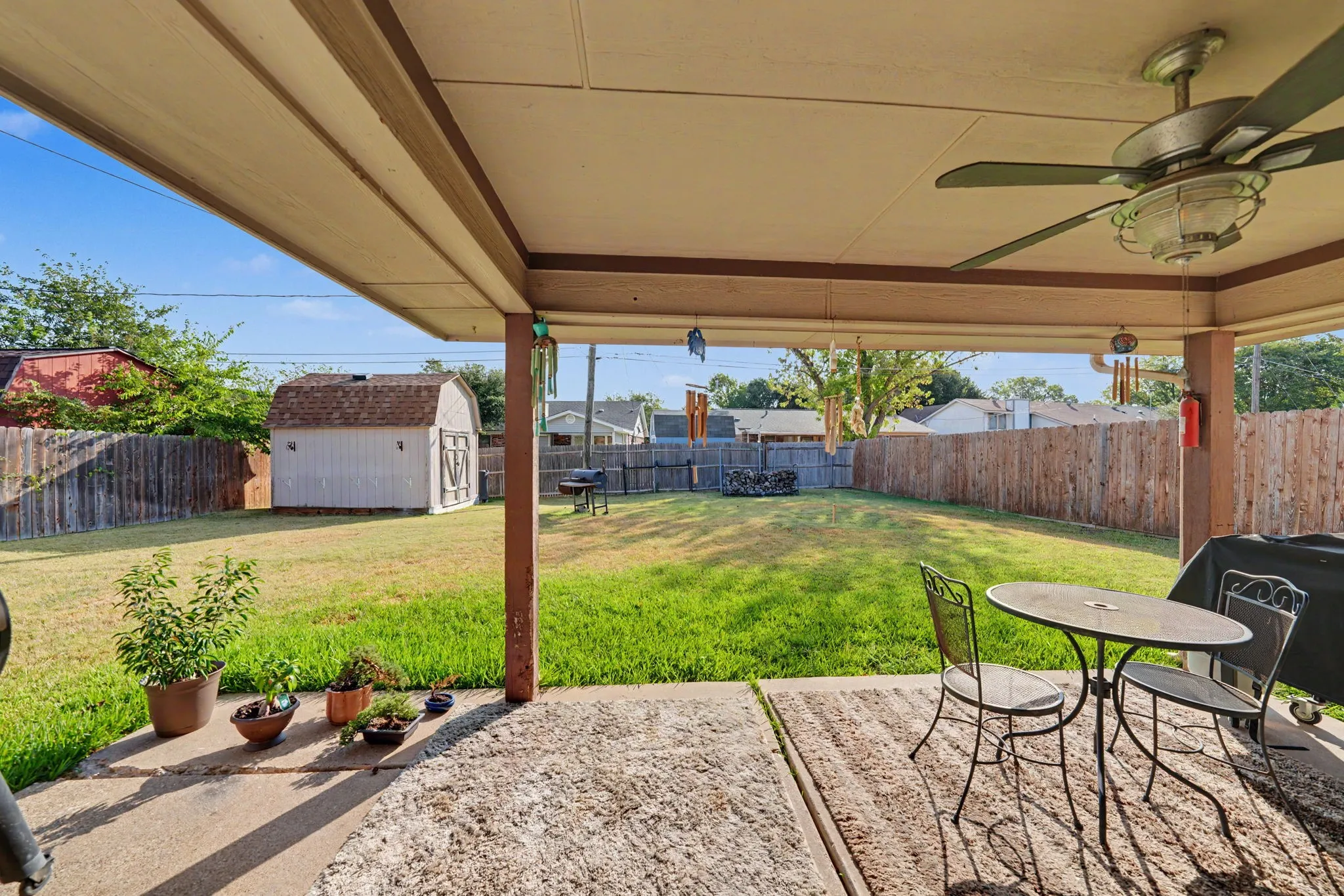 Covered patio with a ceiling fan, concrete flooring, and an expansive fenced backyard