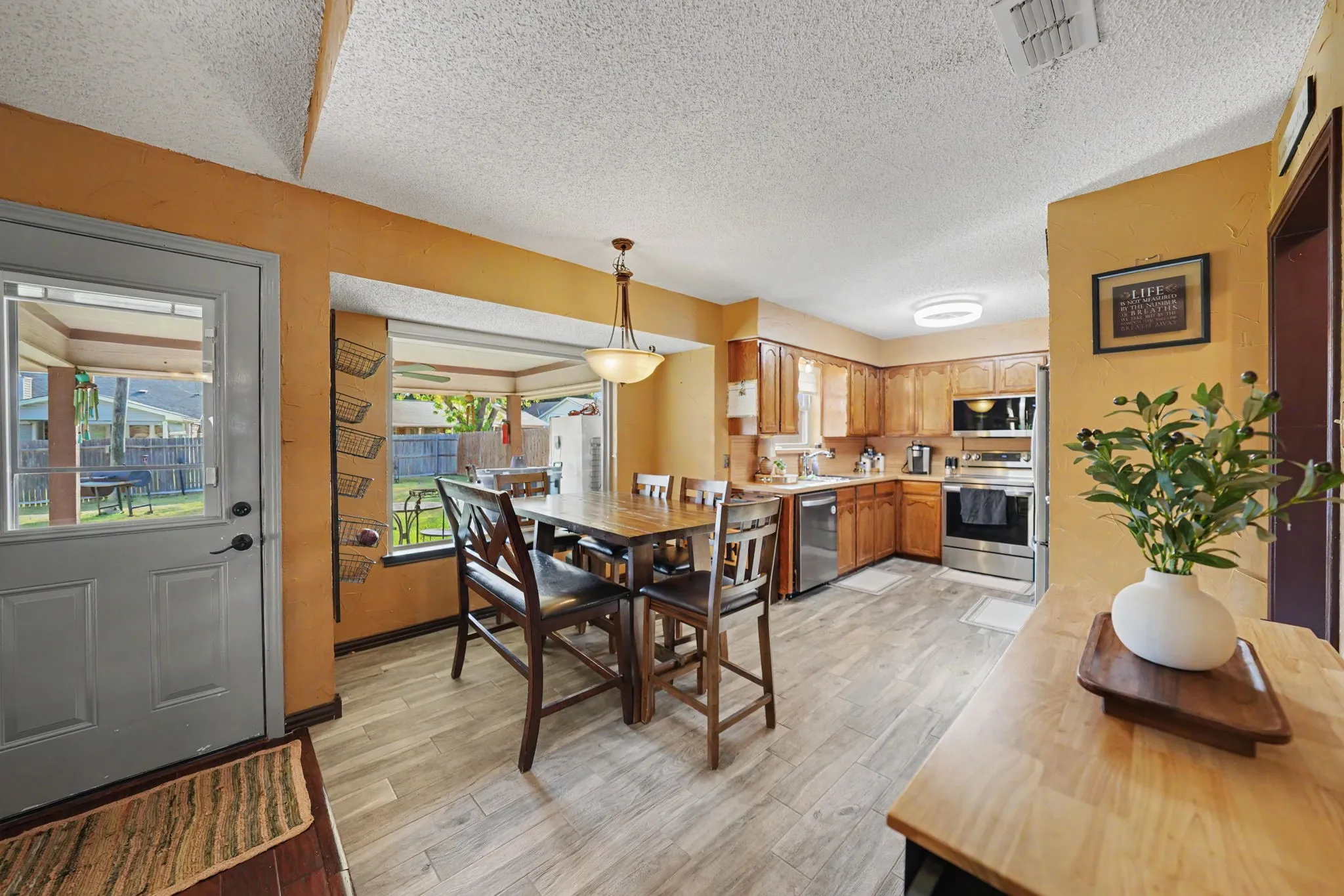 Kitchen featuring wood-finish cabinetry, stainless steel appliances, and light-toned flooring