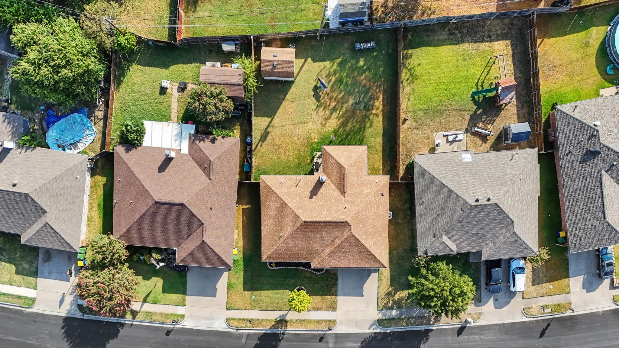 Residential property with a gabled roof, paved driveway, and fenced backyard