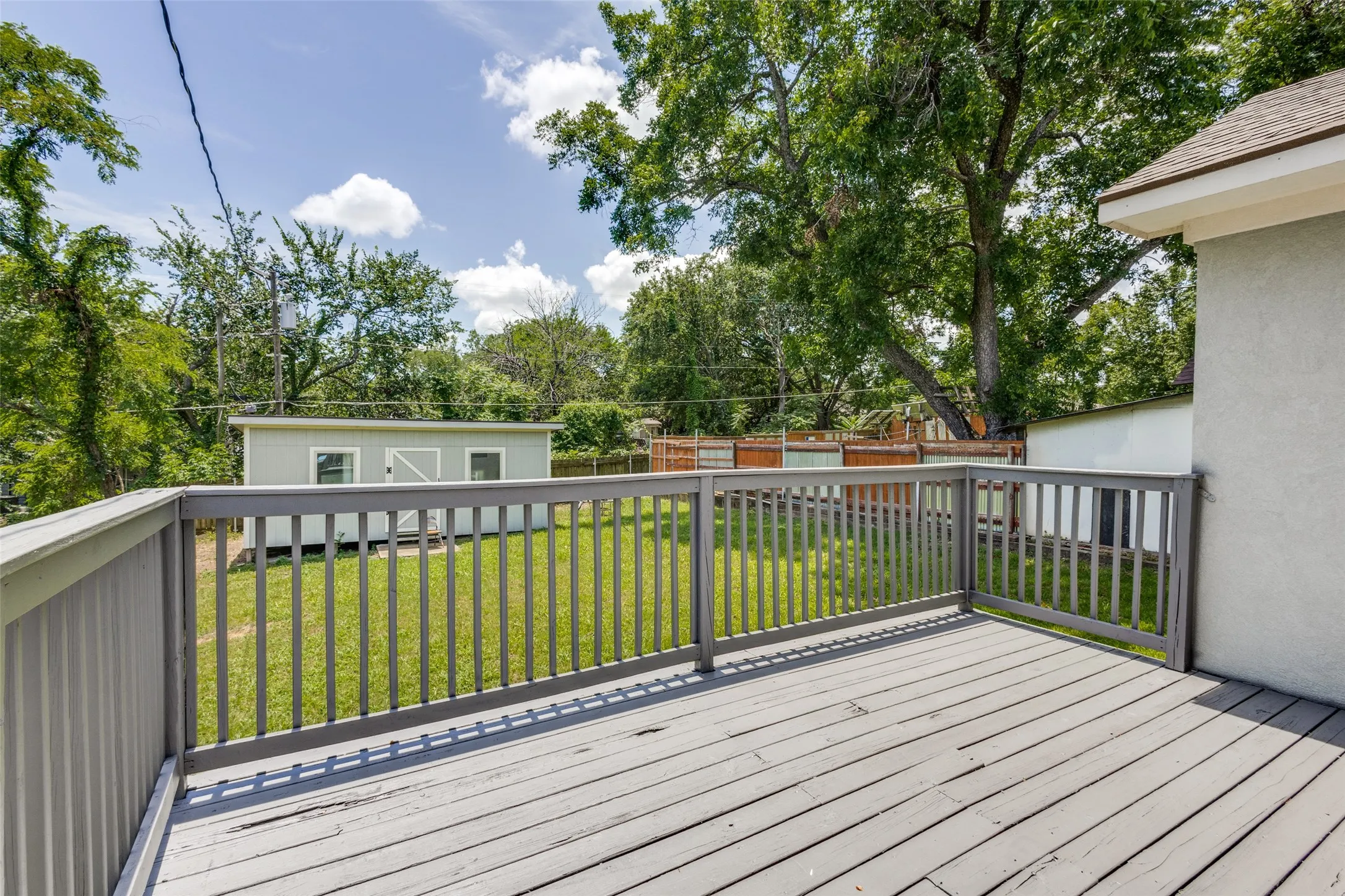 Expansive outdoor deck with gray wood-finish flooring and matching railings