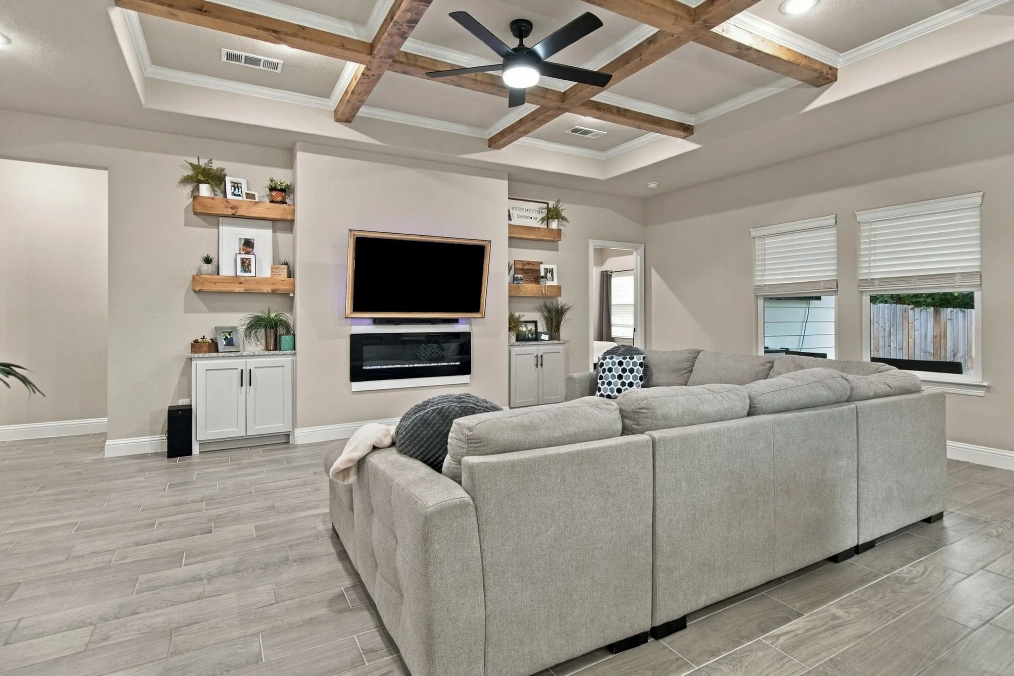 Coffered ceiling with exposed wood beams, ceiling fan, and recessed lighting